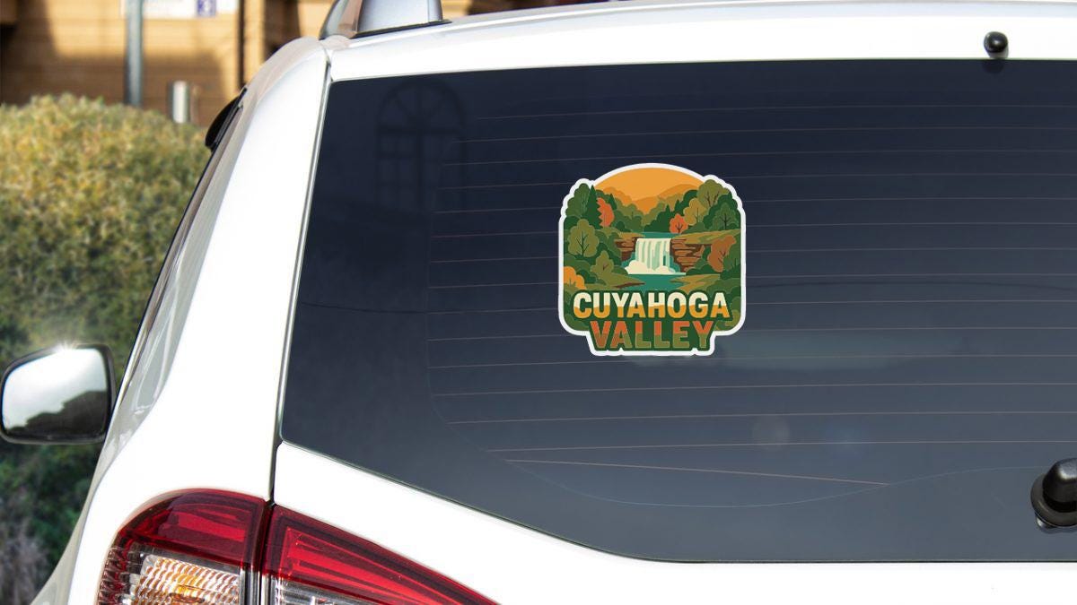 A sticker on the rear window of a white car that says "Cuyahoga Valley".