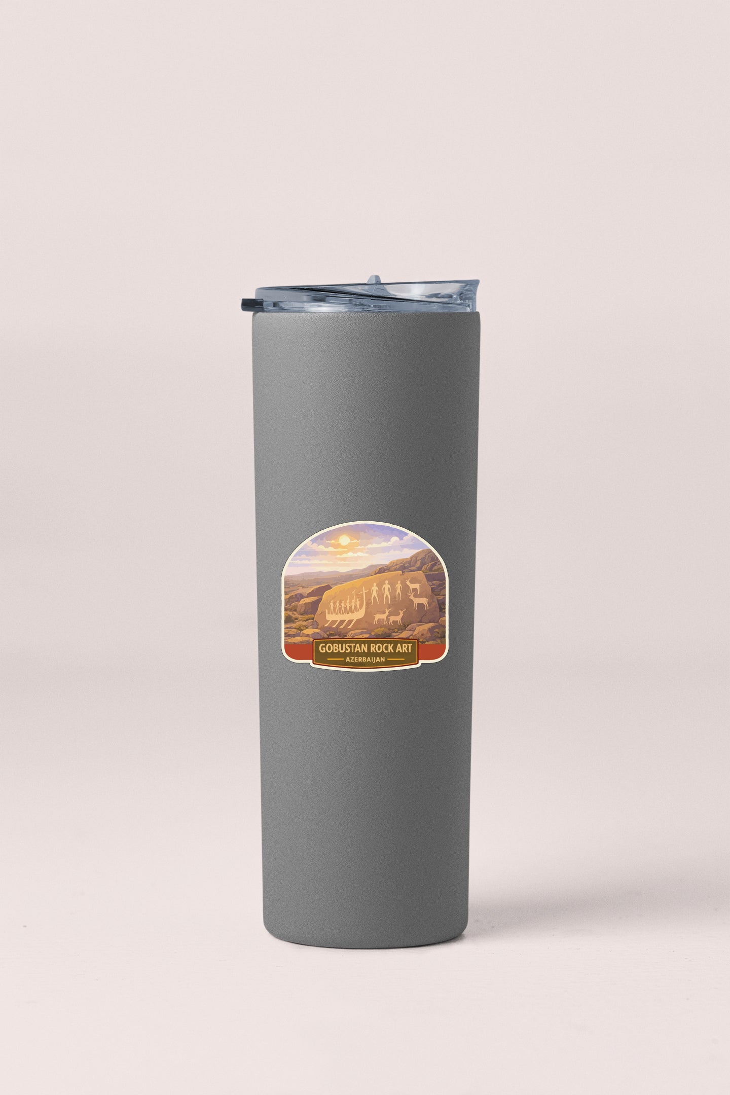A gray cylindrical container with a lid and a label featuring an image of a desert landscape.