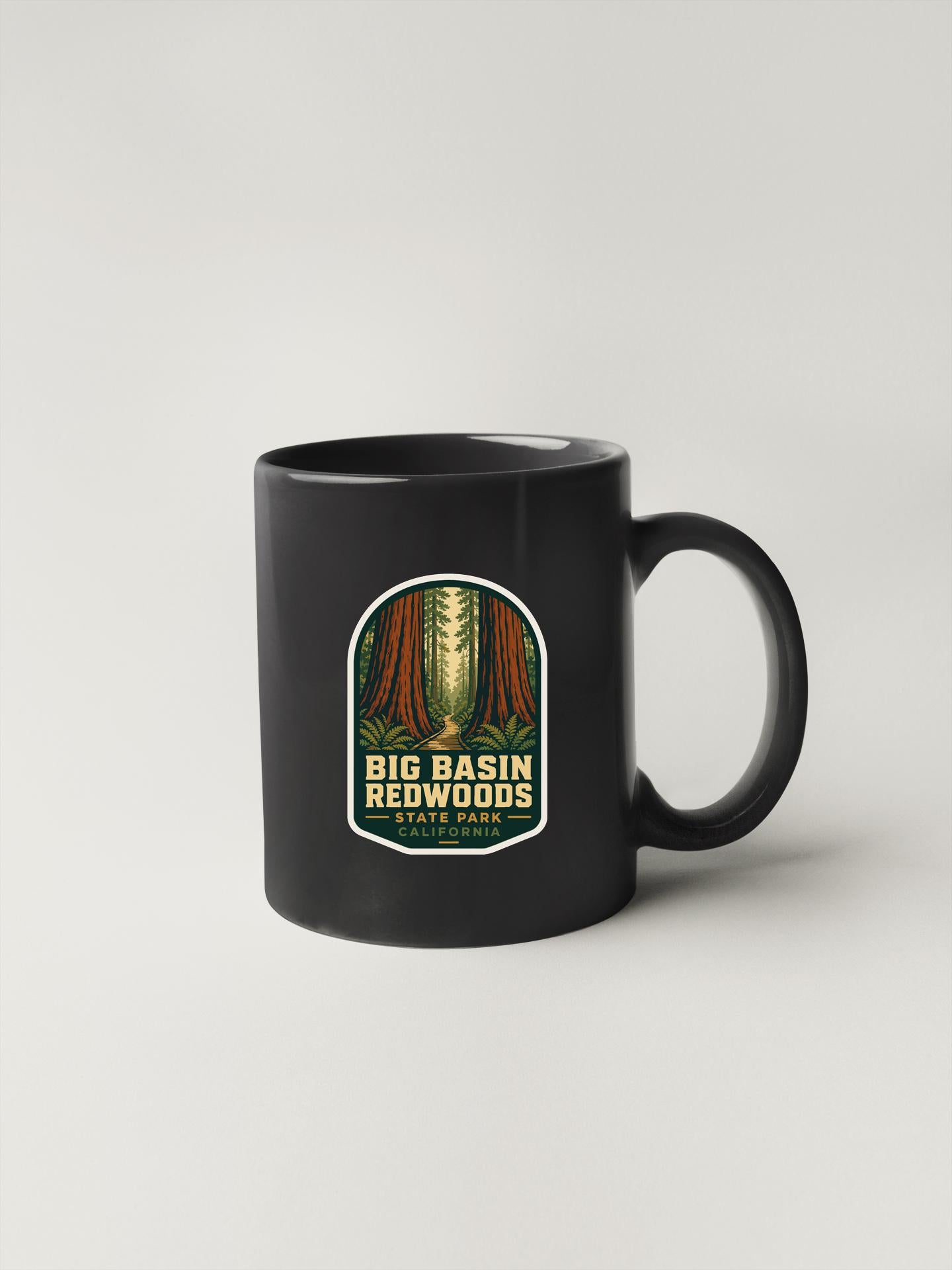 A black coffee mug with a label that says "Big Basin Redwoods" and "California", featuring an illustration of a forest.
