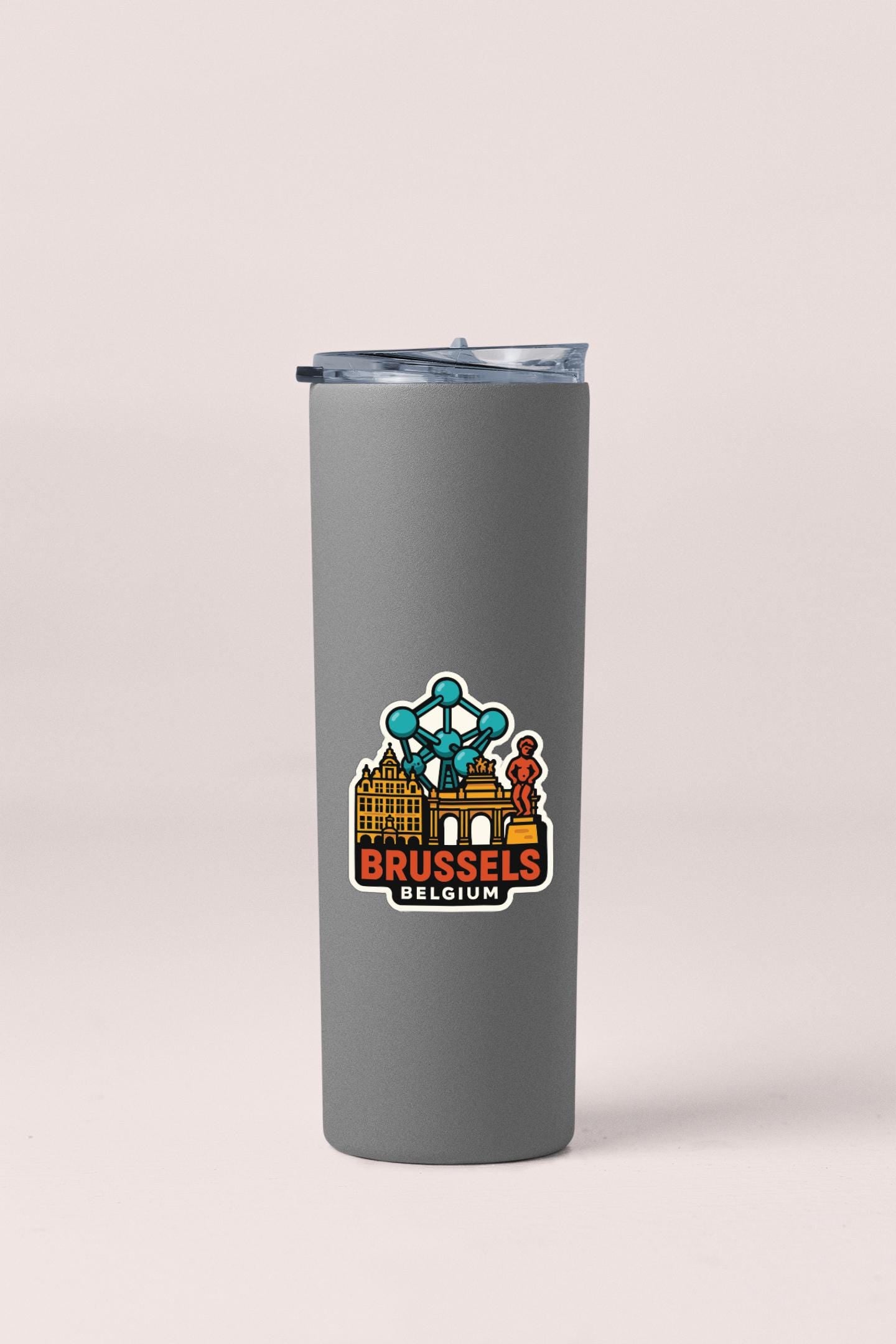 A gray insulated tumbler with a sticker depicting the Brussels cityscape.