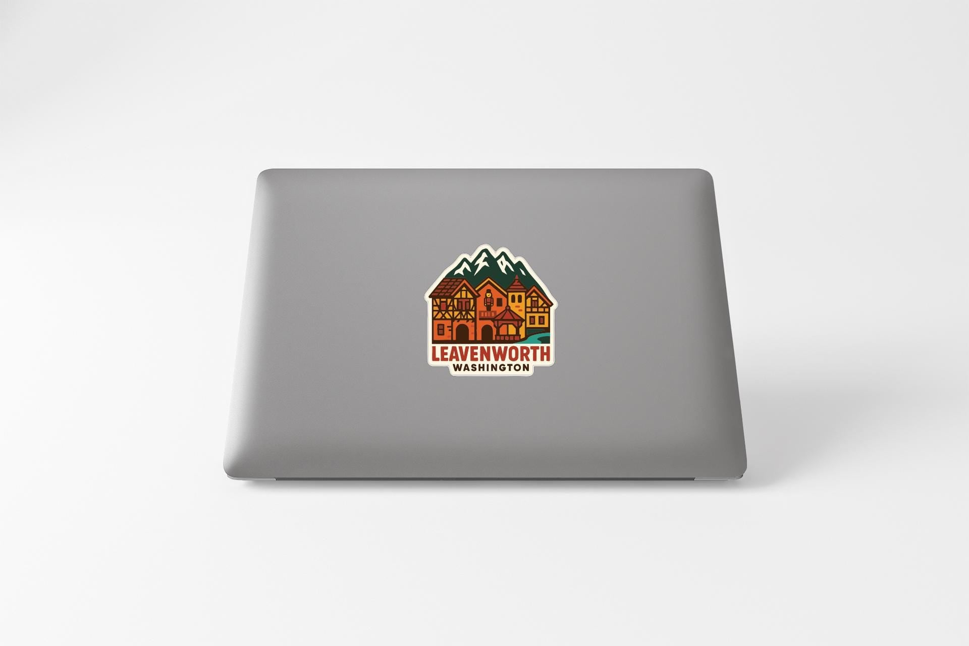 a sticker with a mountain and a house on a laptop.