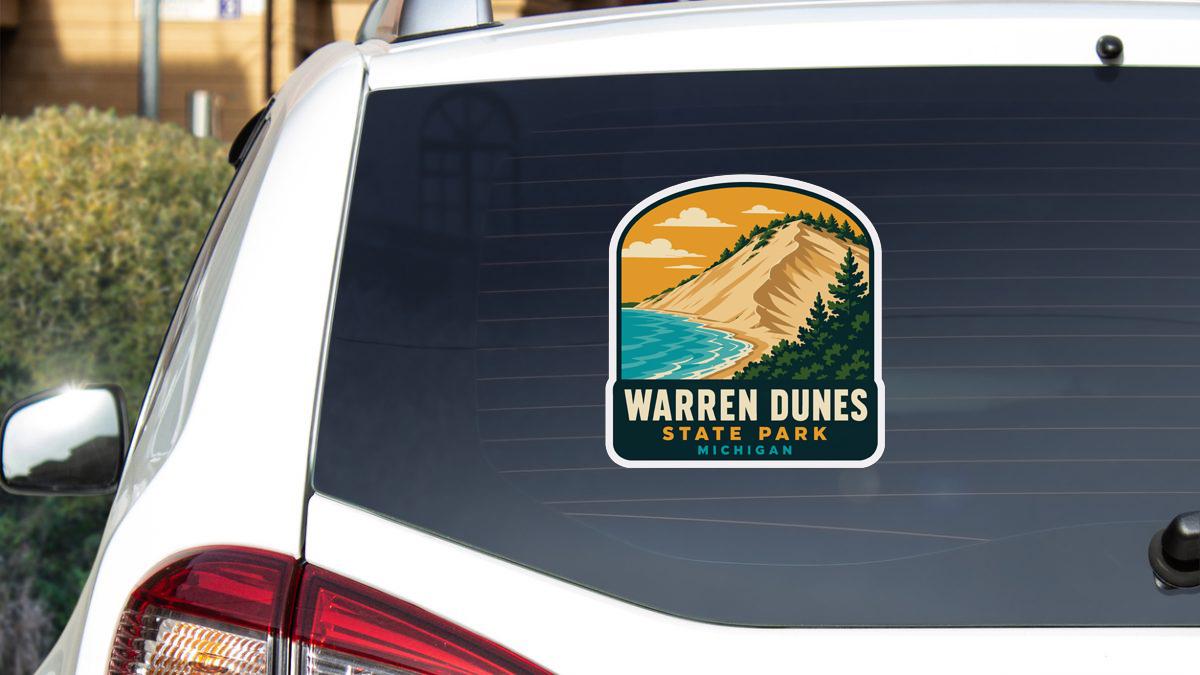 A sticker on the rear window of a car that says " Warren Dunes State Park Michigan".
