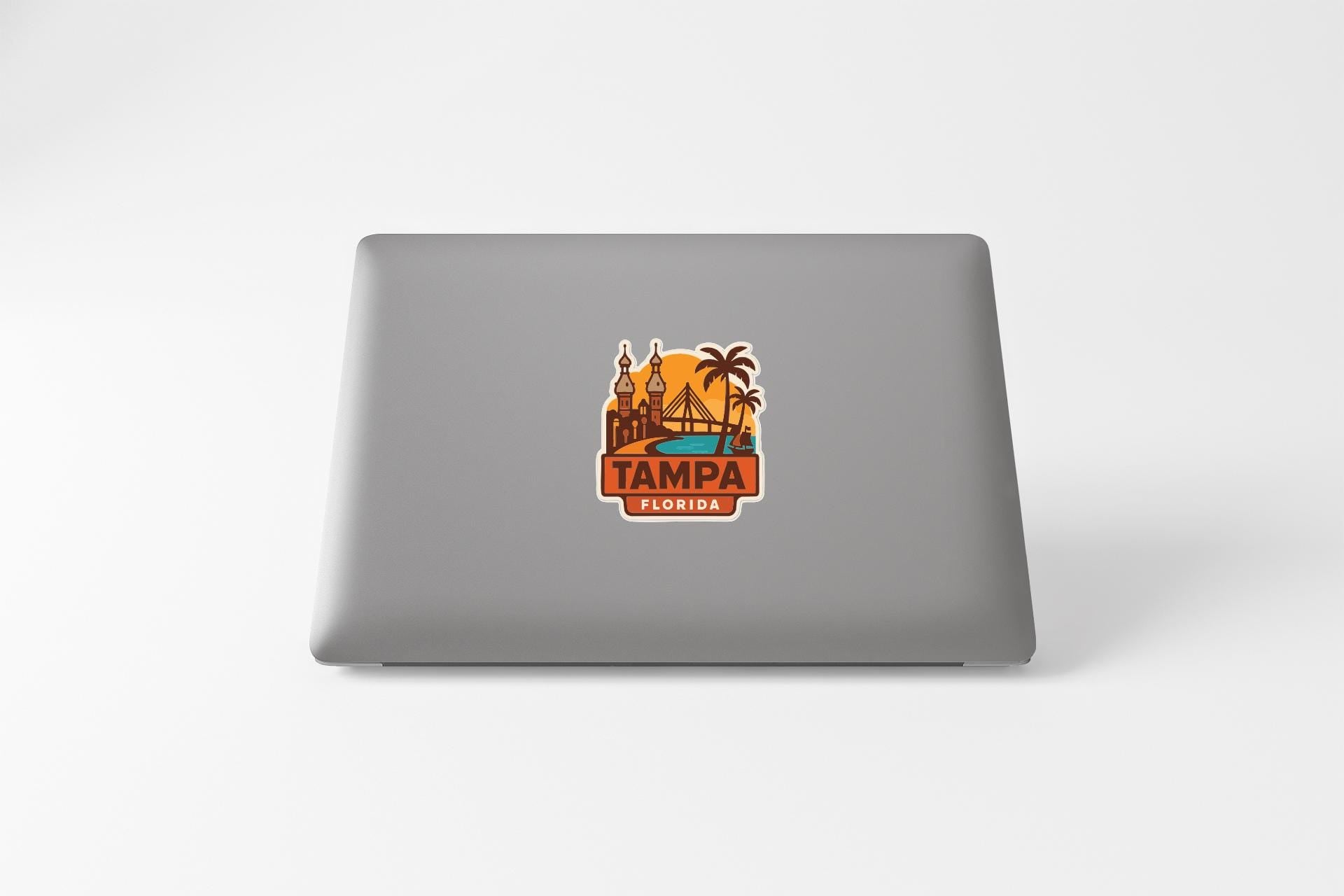 A sticker on the back of a laptop displaying the text "TAMPA FLORIDA" along with an illustration of a cityscape and palm trees.