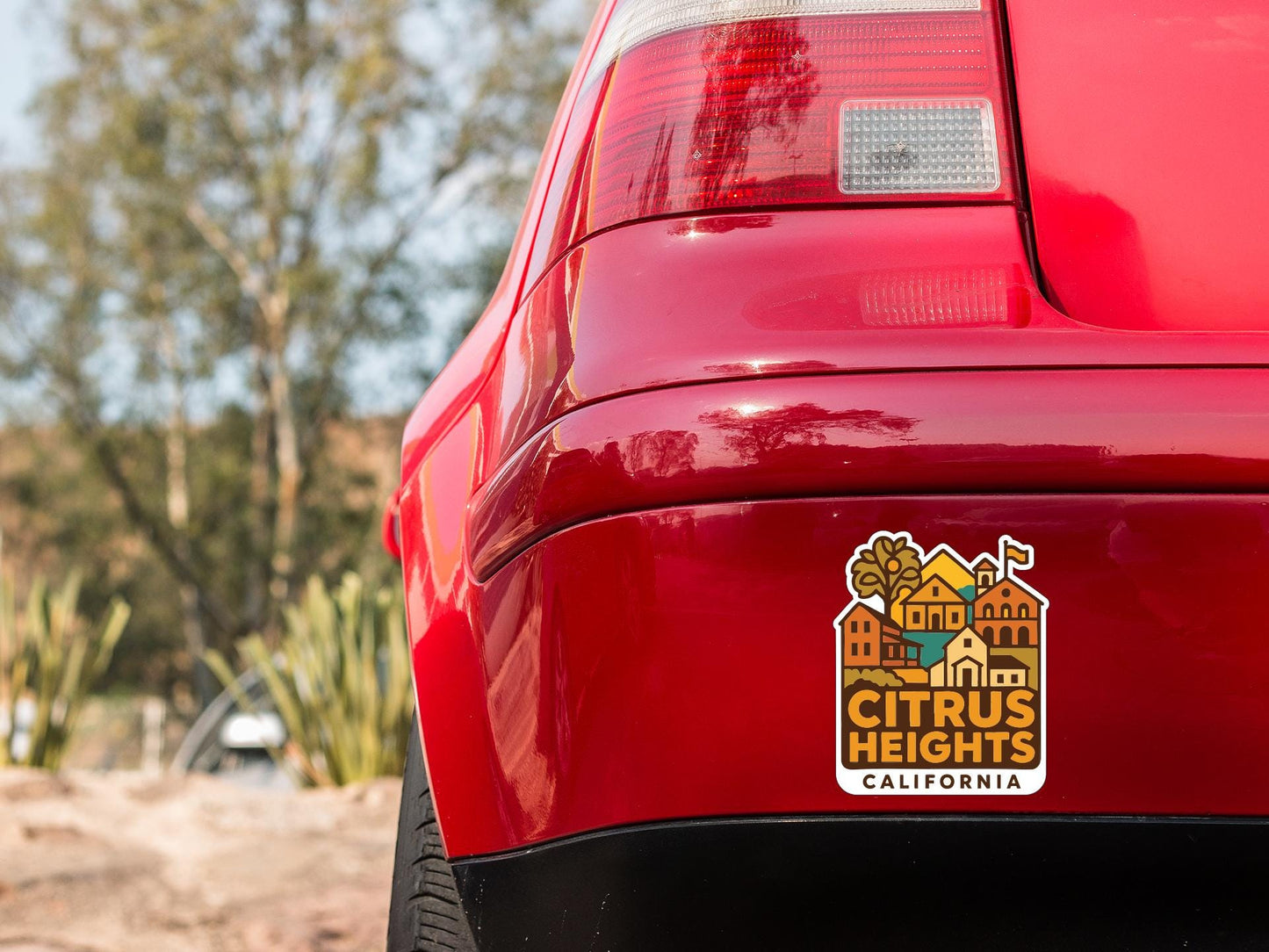 the rear end of a red car with a sticker on the trunk that says "Citrus Heights, California".