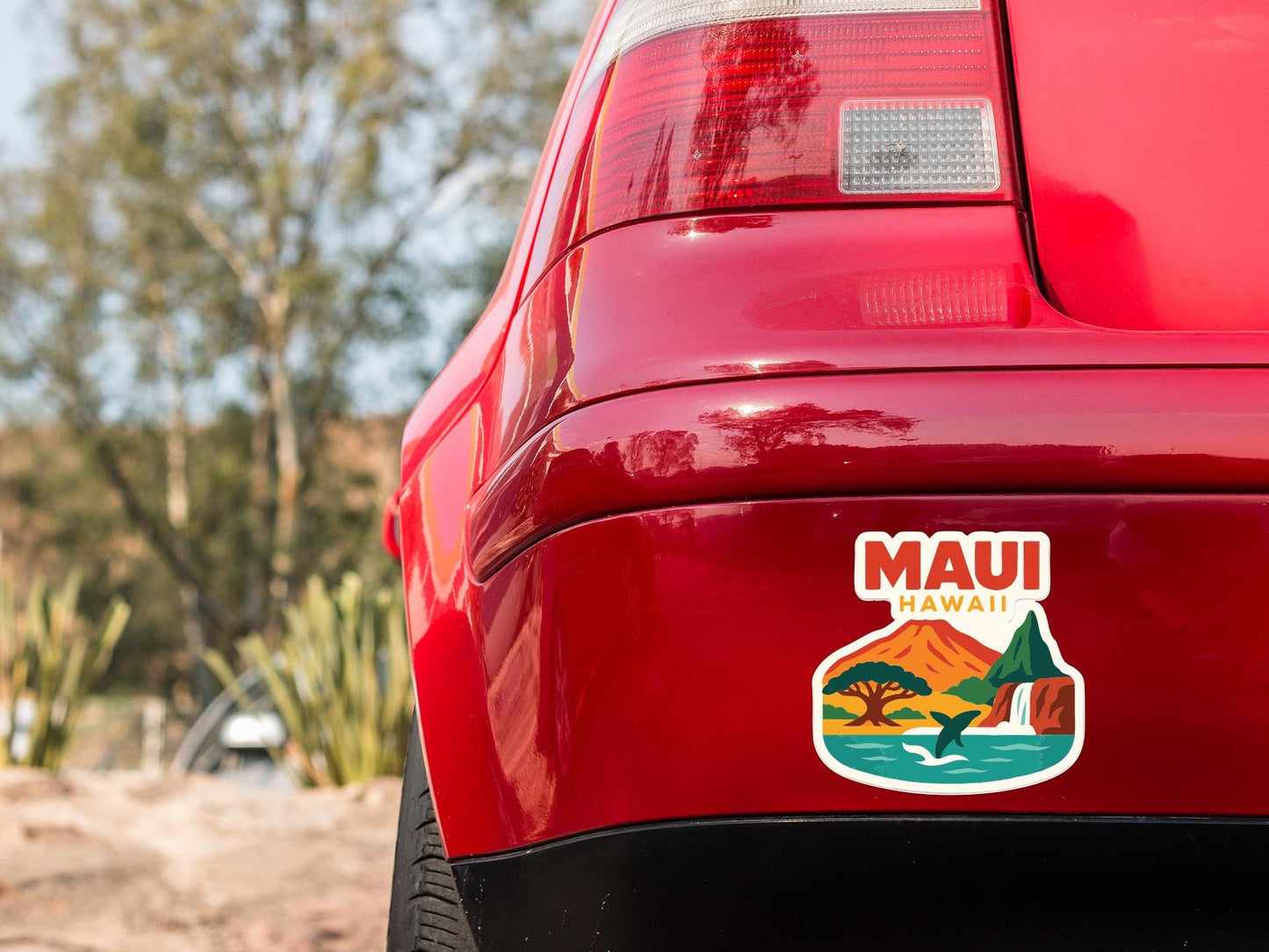 the rear end of a red car with a sticker on the back window that says "Maui Hawaii".