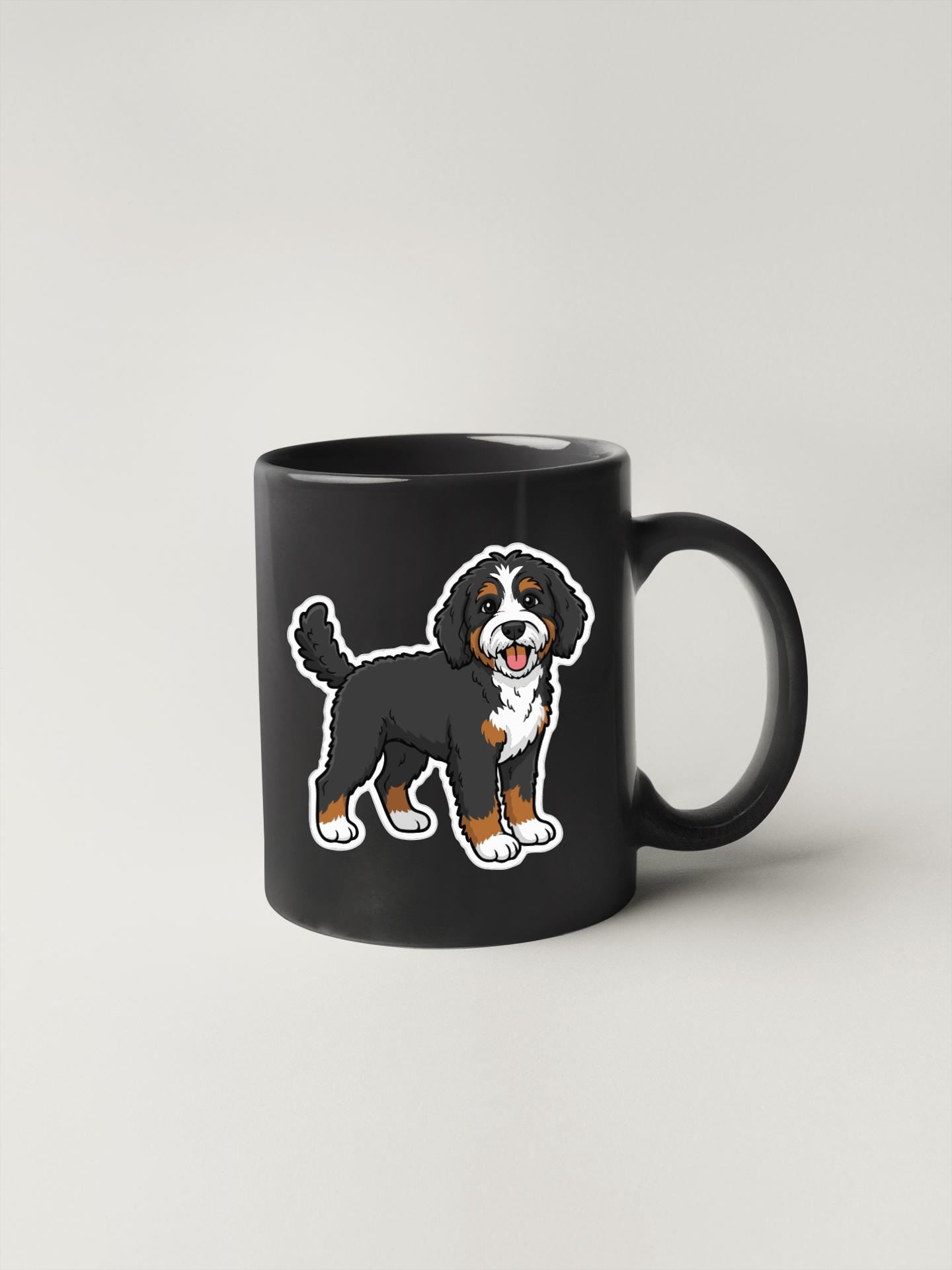 A black coffee mug with a cartoon illustration of a Bernese mountain dog on it.