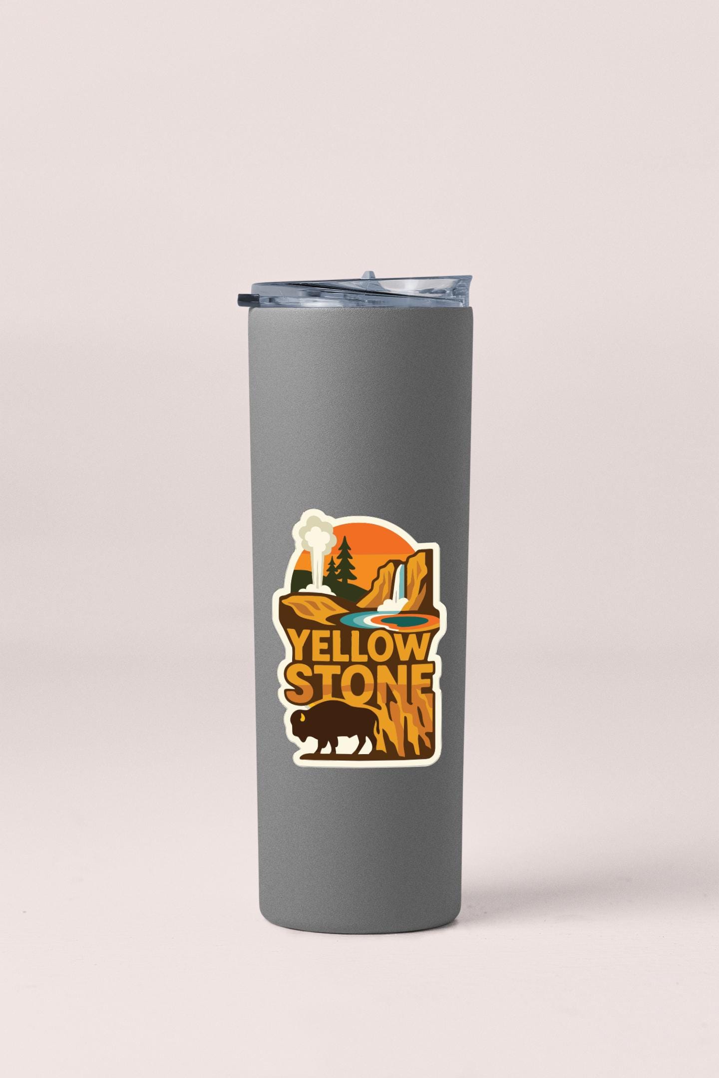 A gray insulated tumbler with a sticker depicting a scenic landscape featuring a waterfall and mountains.