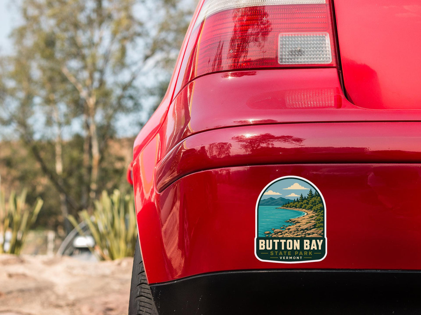 the rear end of a red car with a sticker on the bumper that says "BUTTON BAY, VIRGINIA".