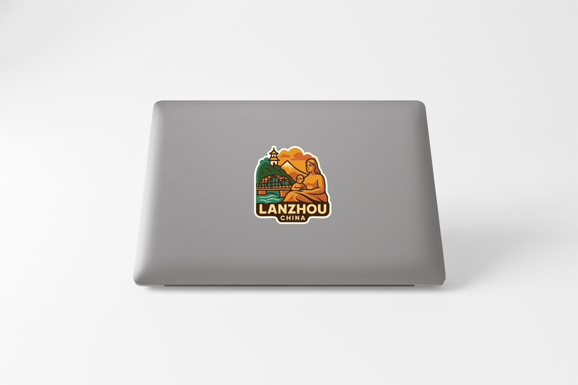 a sticker or logo on the back of a laptop, depicting a scenic landscape with mountains and a lighthouse.