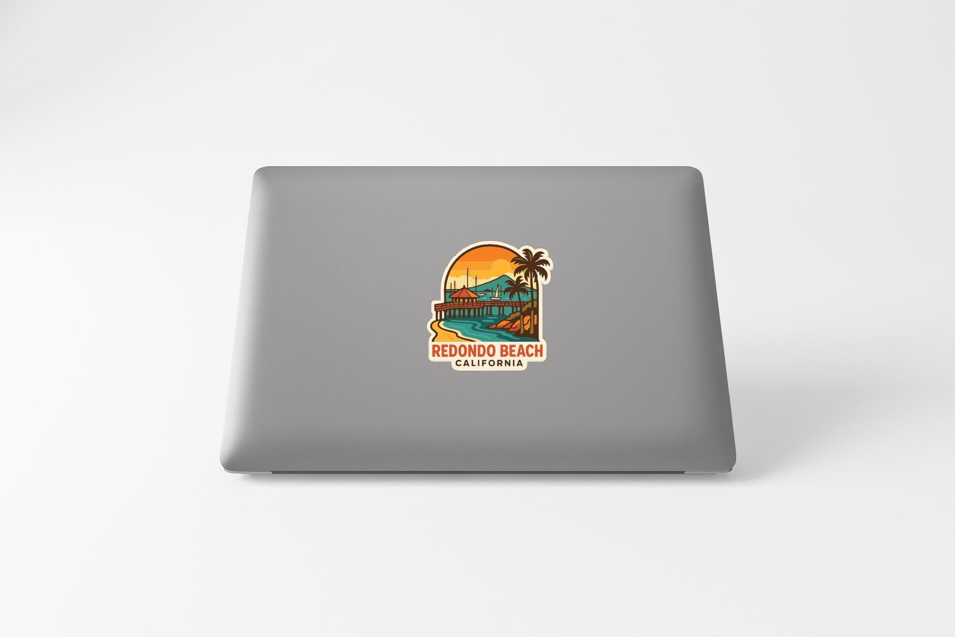 a sticker on the back of a laptop that says "REDONDO BEACH CALIFORNIA".