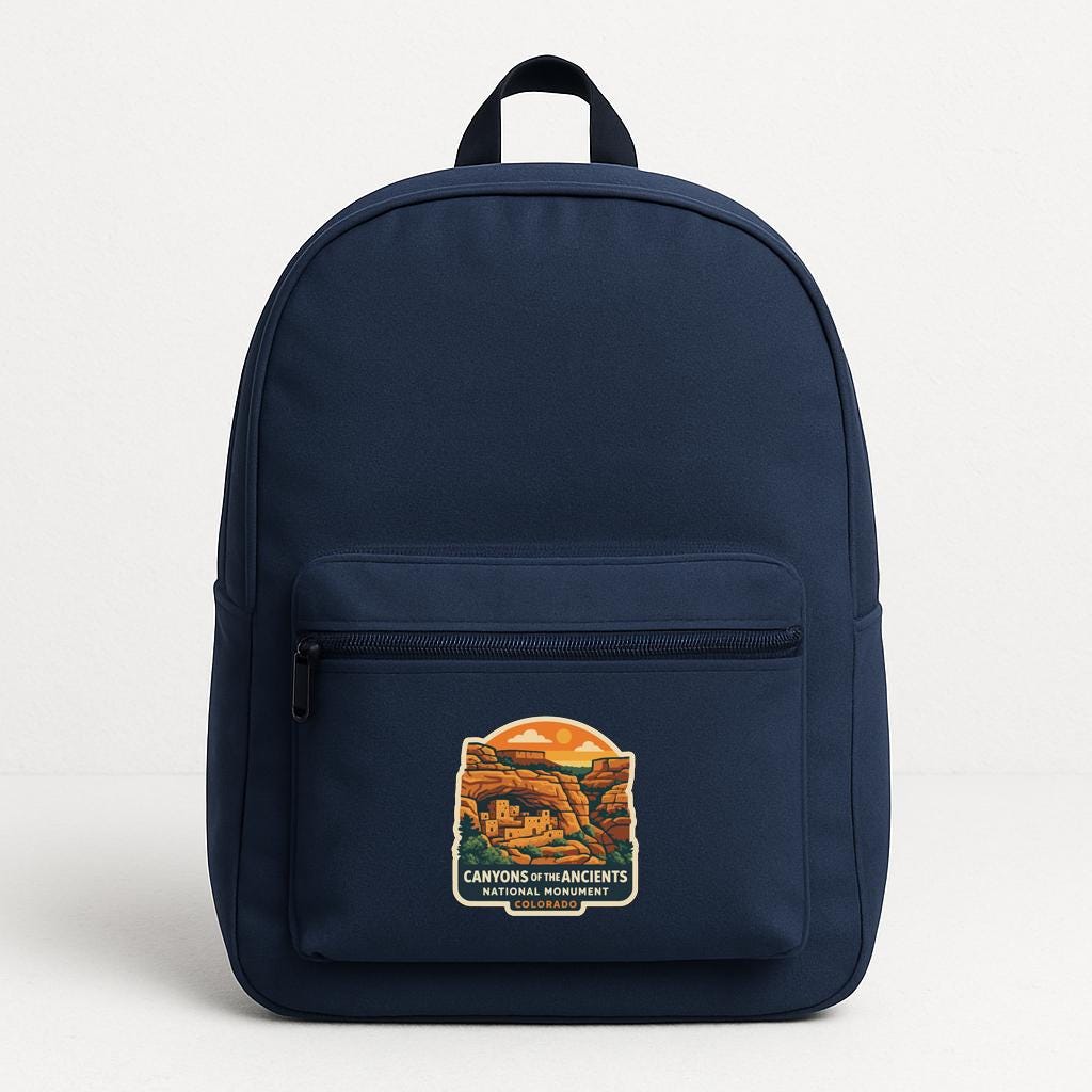 A navy blue backpack with a printed label that says "Canyons of the Ancients National Monument".