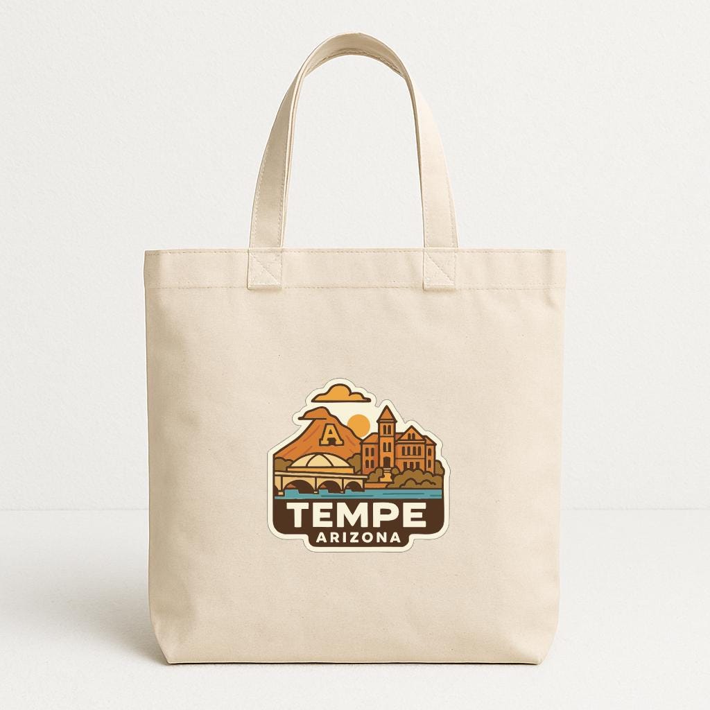 A beige tote bag with a printed design of a cityscape and the text "TEMPE ARIZONA" printed on it.