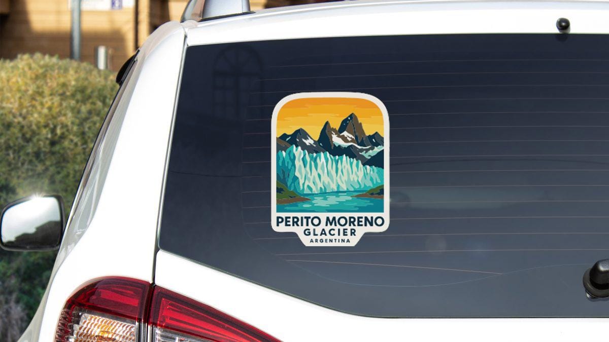 A sticker on the rear window of a car, depicting a scenic mountain landscape with a river.