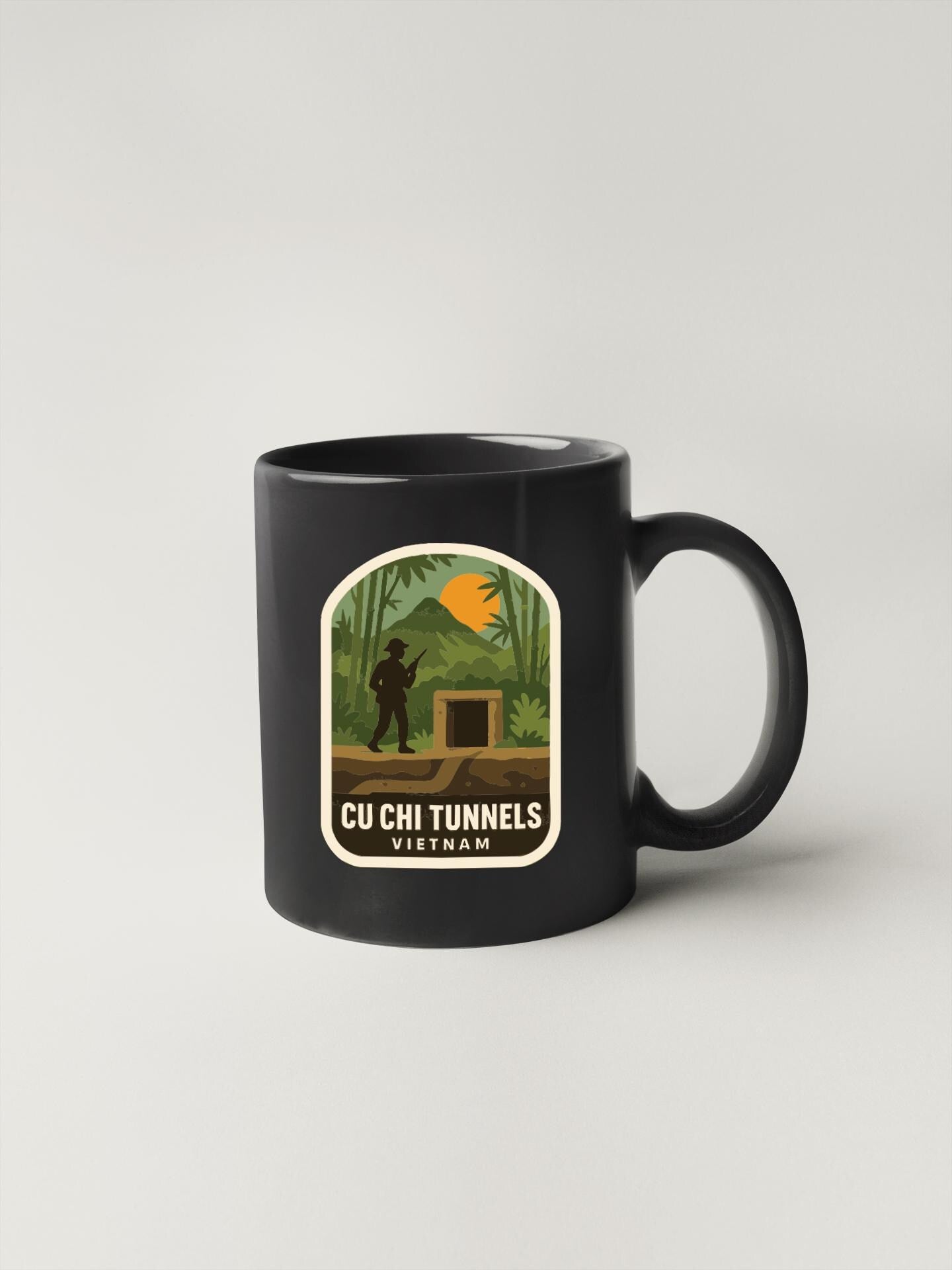 A black coffee mug with a label that features a silhouette of a person and an illustration of a tunnel, along with the text "CU CHI TUNNELS VIETNAM".