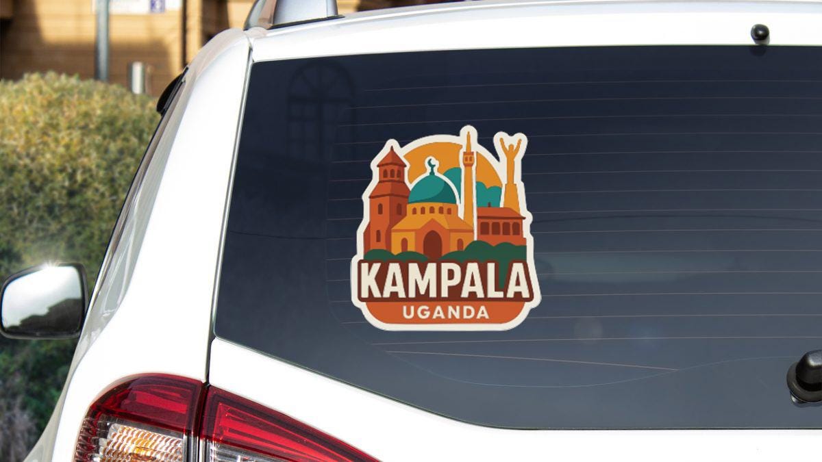 A sticker on the rear window of a car that says "Kampala Uganda".