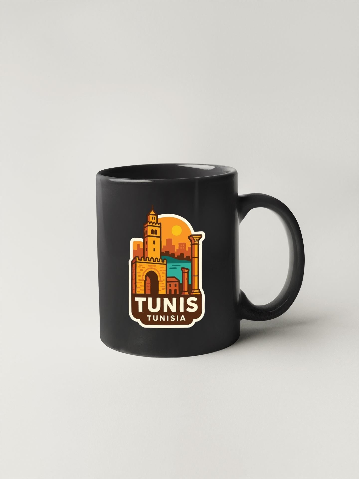 A black coffee mug with a colorful illustration of a city skyline and the text "TUNIS" printed on it.