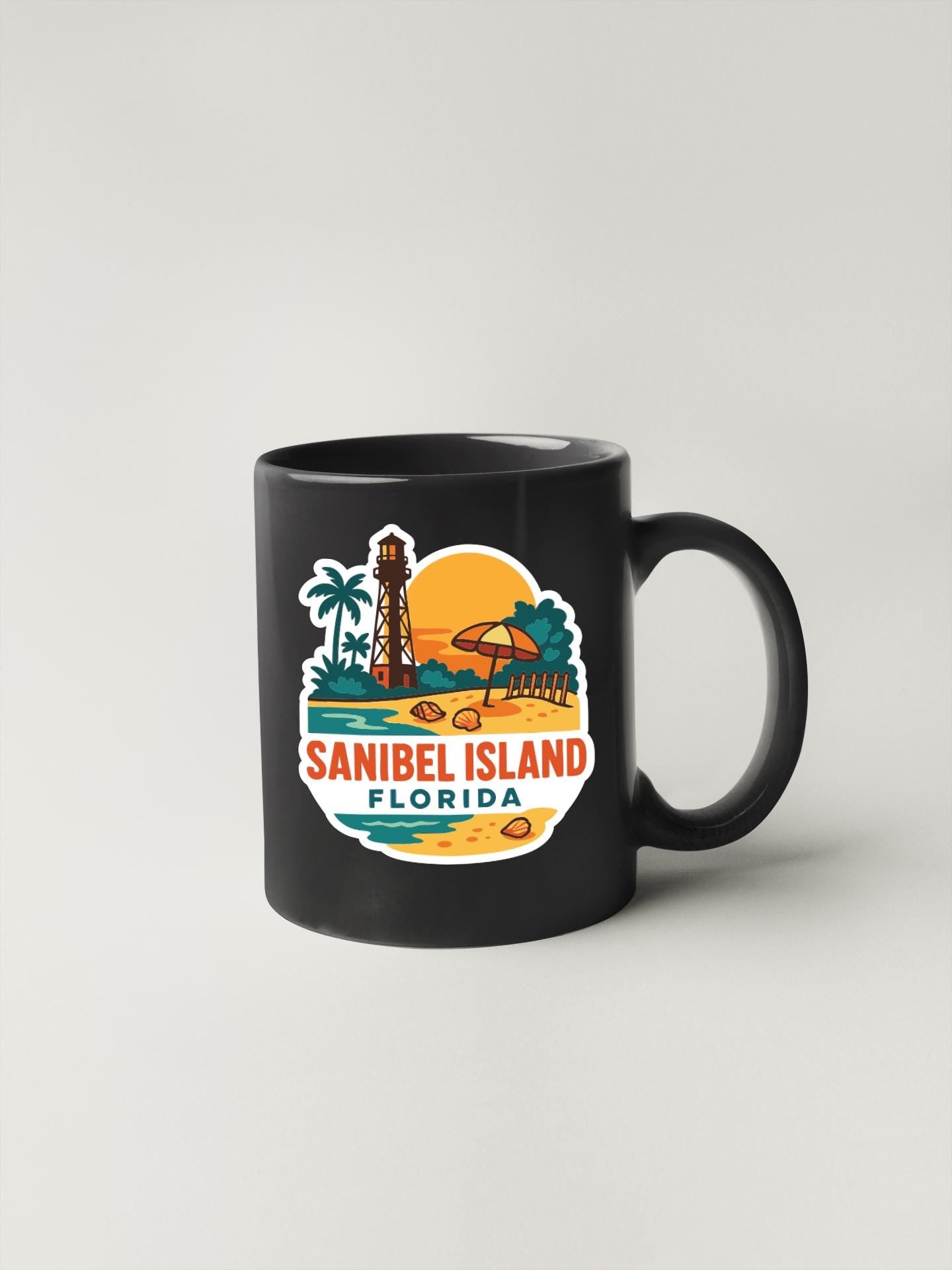 A black coffee mug with a colorful graphic depicting a beach scene and a lighthouse, along with the text "SANIBEL ISLAND FLORIDA".