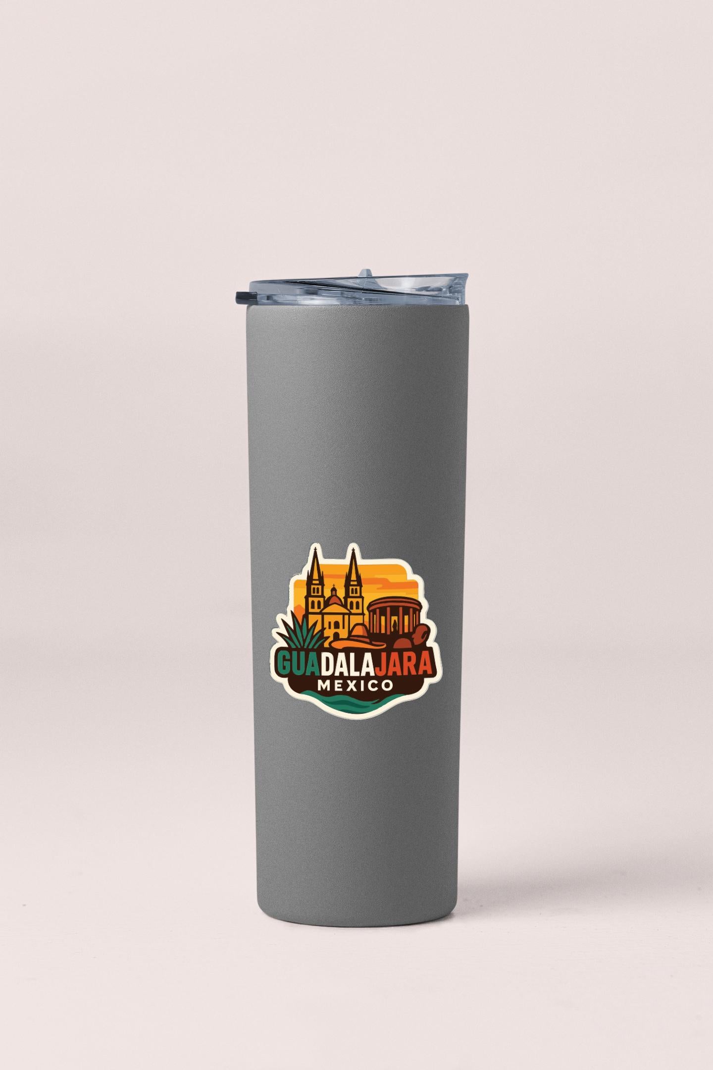 A gray insulated tumbler with a colorful sticker depicting the city of Guadalajara, Mexico.