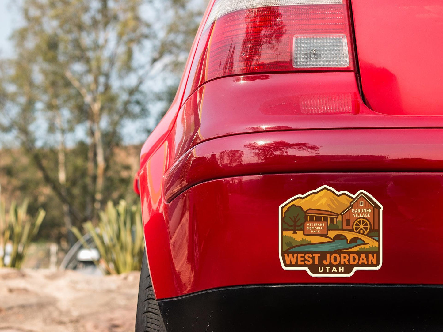 the rear end of a red car with a sticker on the back window that says "West Jordan Utah".