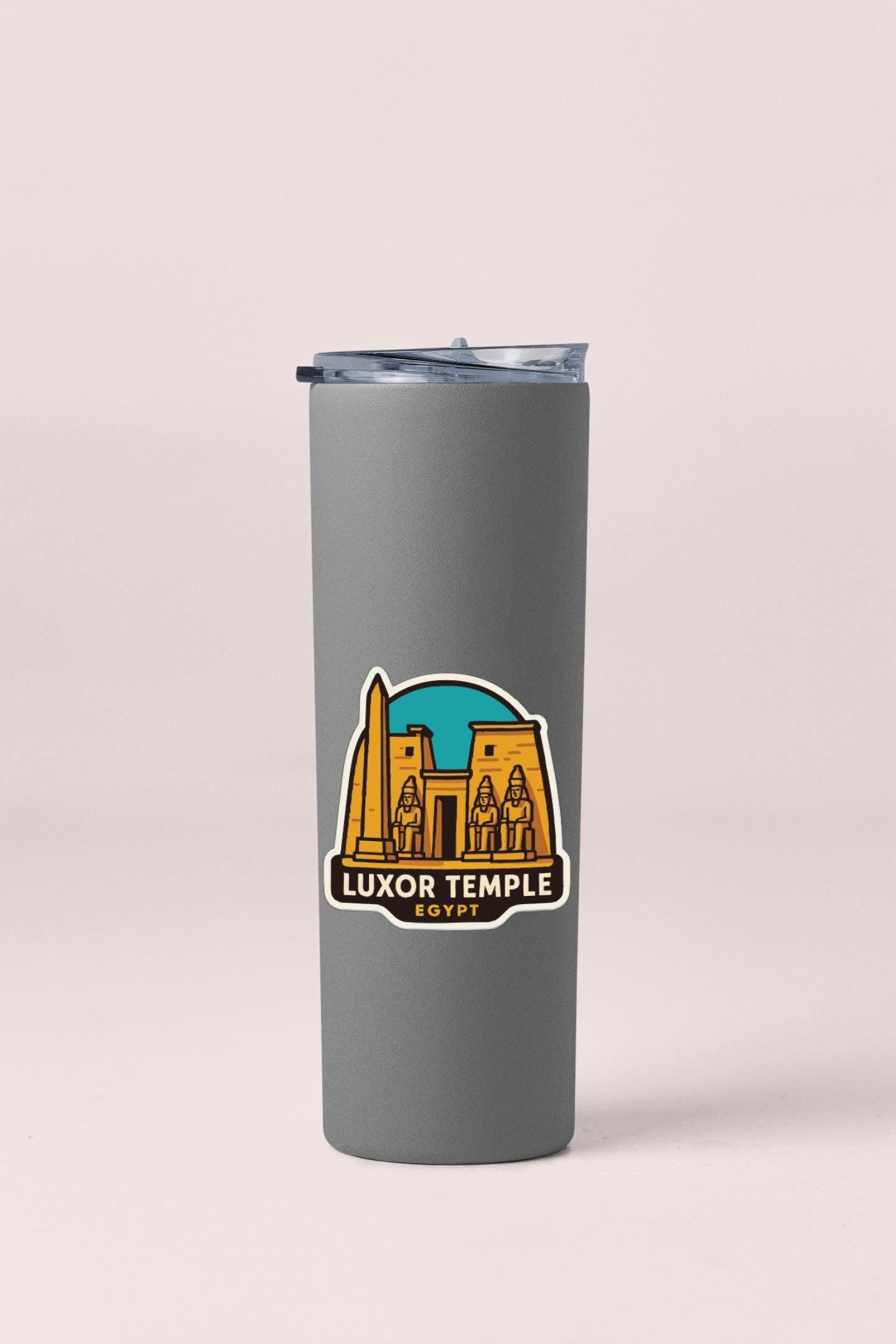 A gray insulated tumbler with a sticker depicting the Luxor Temple in Egypt.
