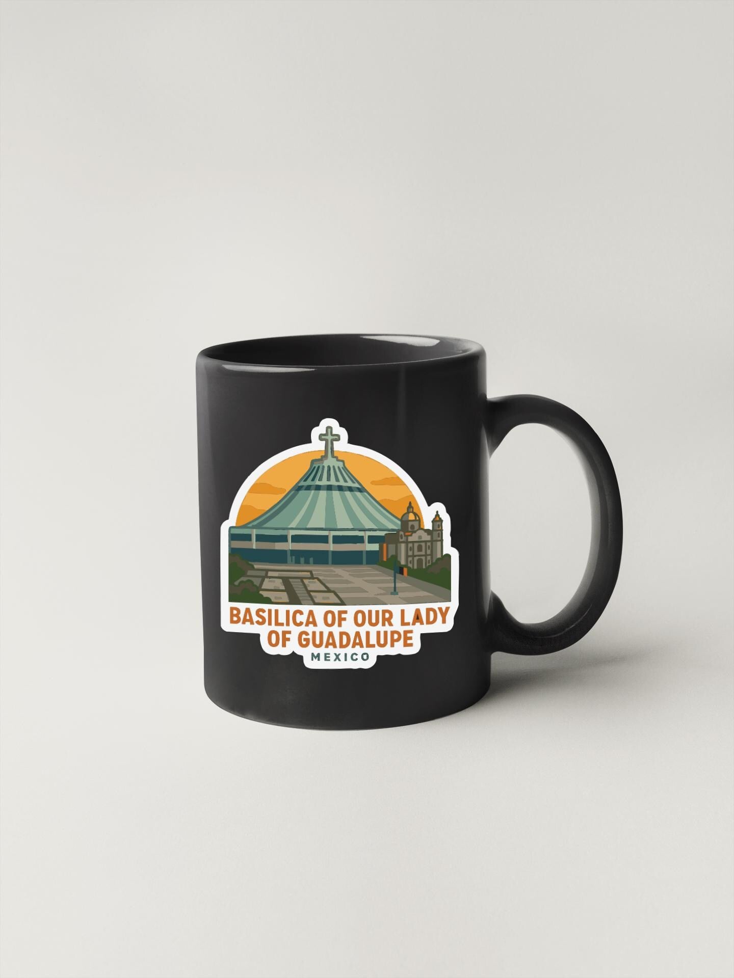 A black coffee mug with a sticker depicting the Basilica of Our Lady of Guadalupe in Mexico.