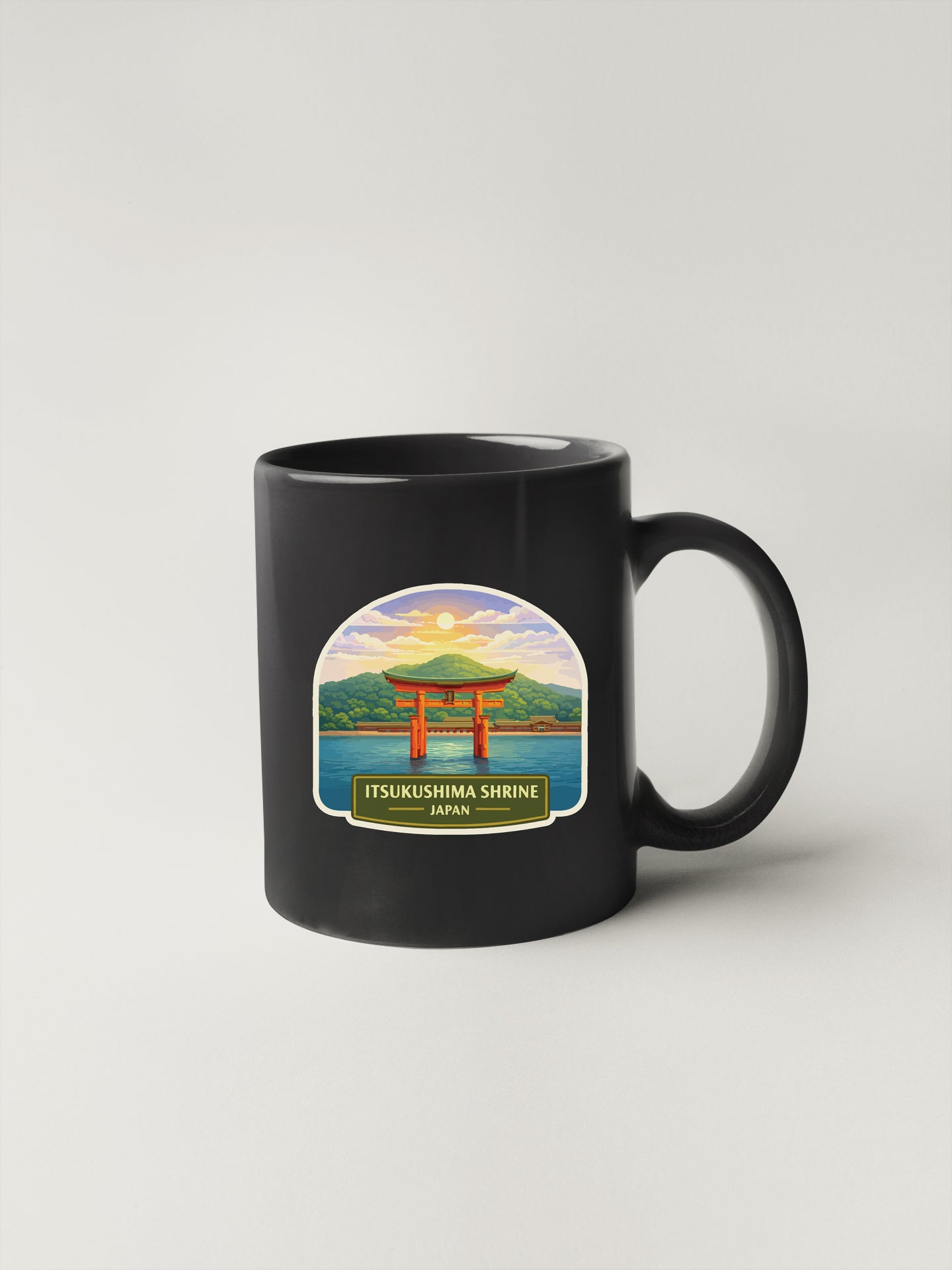 A black coffee mug with a sticker depicting the Itsukushima Shrine in Japan.