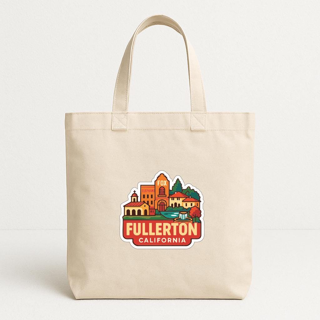 A beige tote bag with a printed design of a cityscape and the text "Fullerton, CA" printed on it.