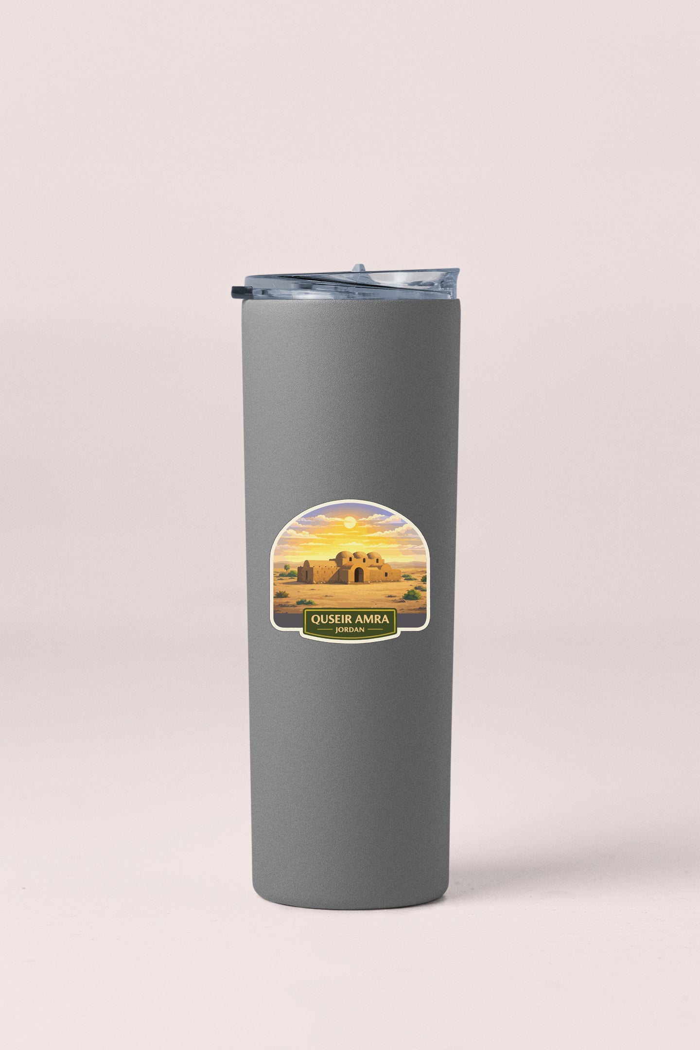 A gray cylindrical container with a lid and a label featuring a desert landscape with a castle in the background.