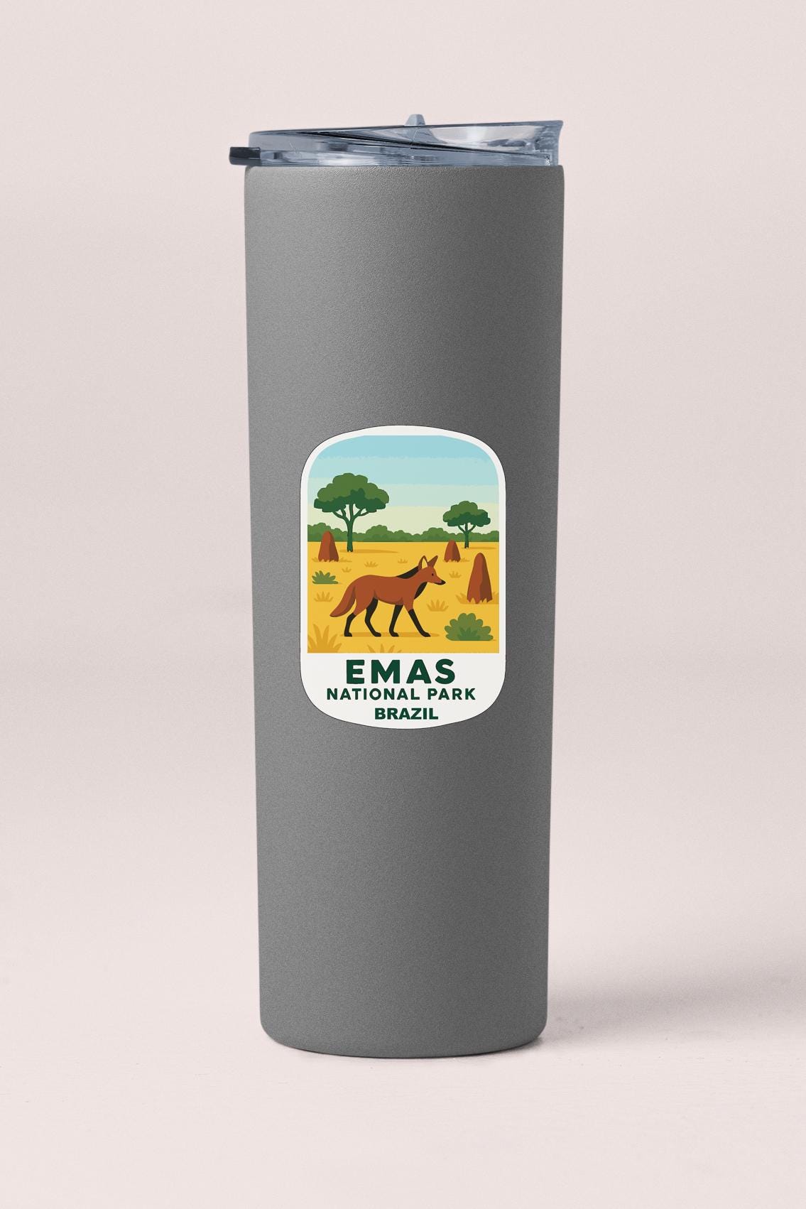 A gray insulated tumbler with a label that features an illustration of a fox in a field, along with the text "EMAS NATIONAL PARK BRAZIL".