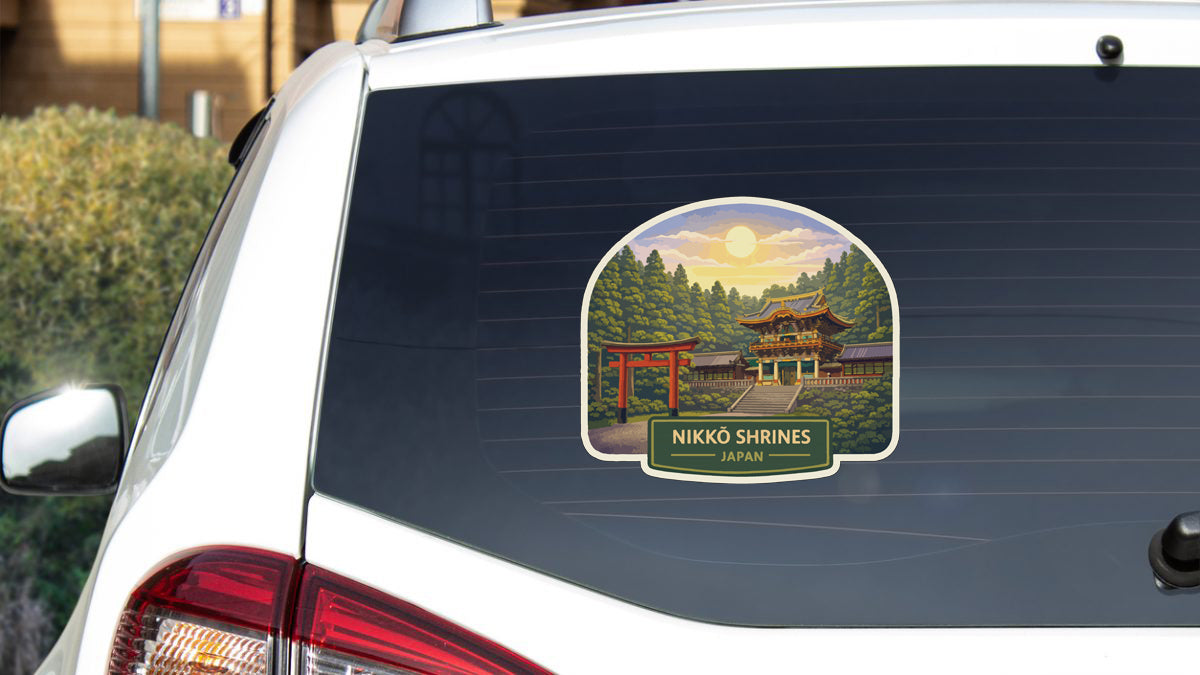 A sticker on the rear window of a car depicting a scenic landscape with a temple in the background.