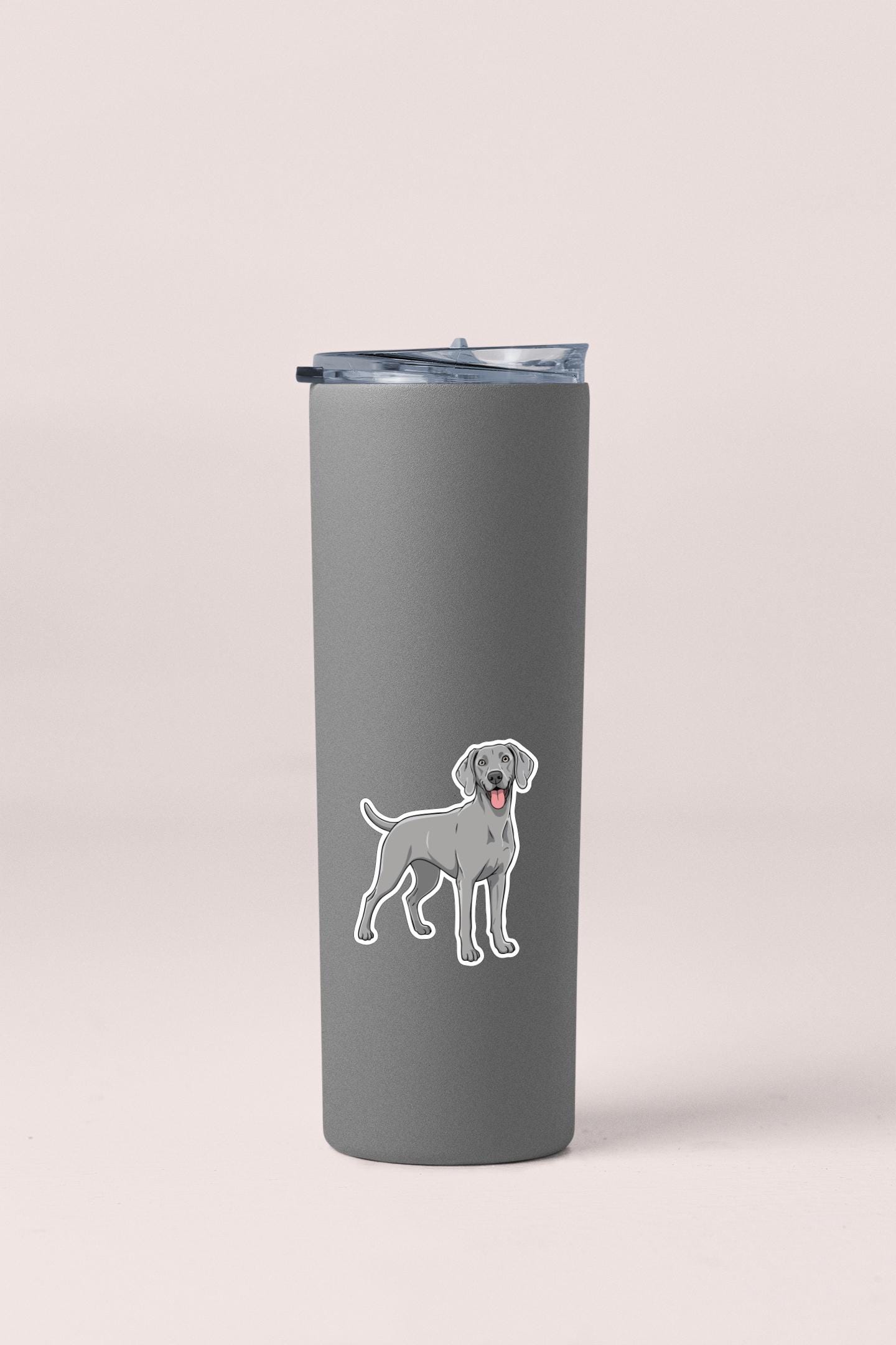 A gray insulated tumbler with a sticker of a dog on it.