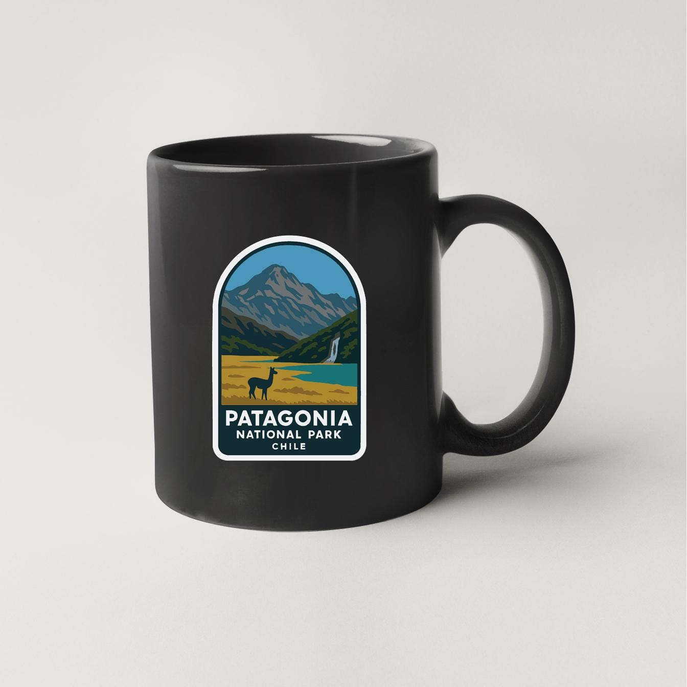 A black coffee mug with a graphic design depicting Patagonia National Park in Chile.