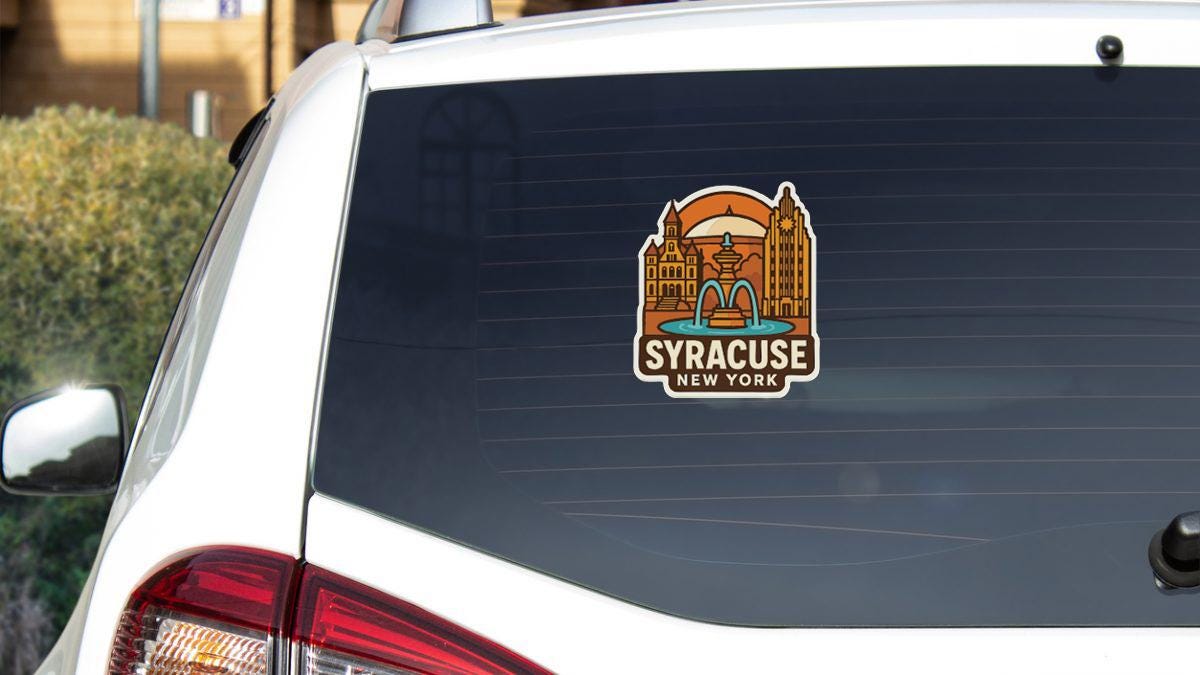 A sticker on the rear window of a white car, depicting a cityscape with a fountain and the text "Syracuse, New York".