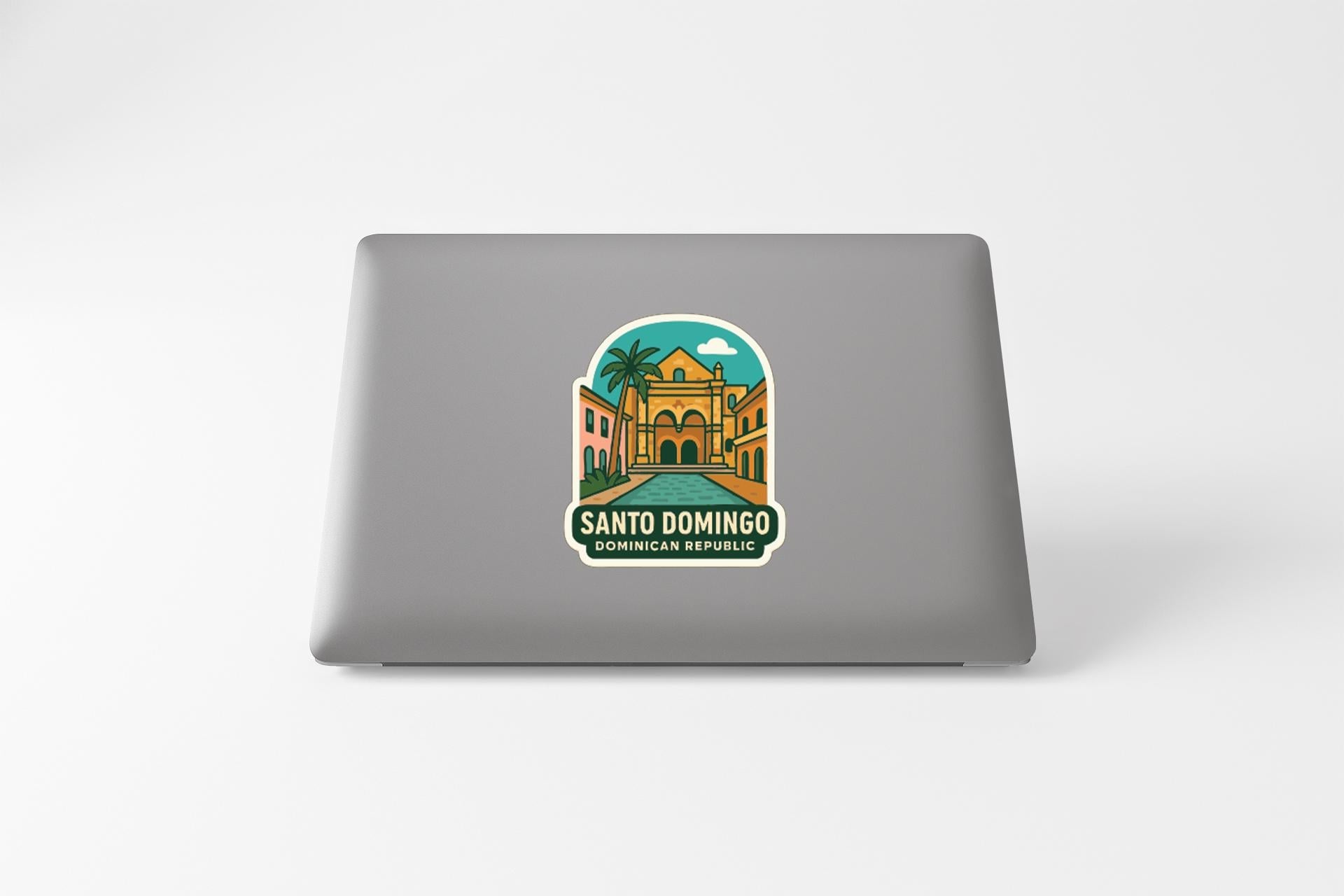 A sticker on the back of a laptop, depicting a tropical scene with a building and palm trees.