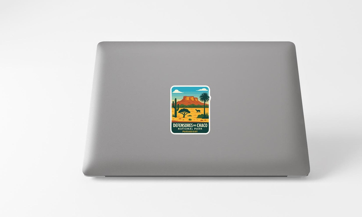 A sticker on the back of a laptop, depicting a desert landscape with mountains and a palm tree.