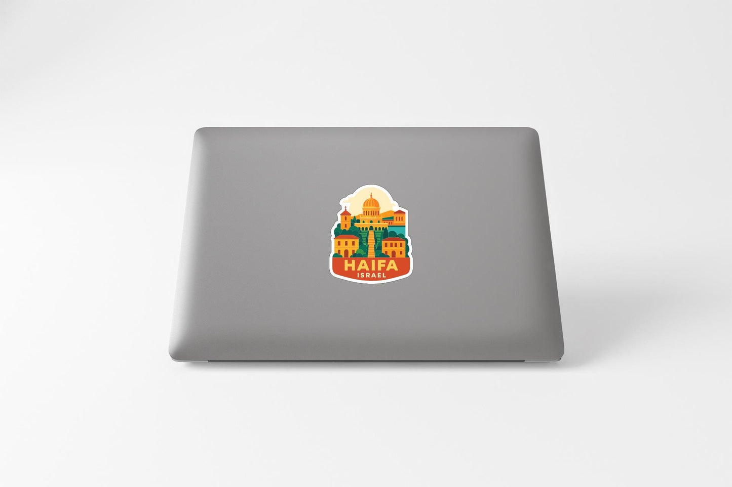 A sticker featuring a colorful illustration of Haifa, Israel, on the back of a laptop computer.