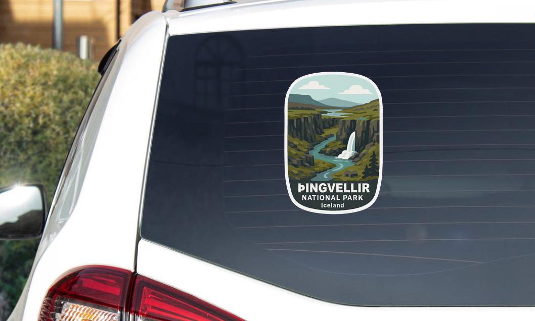 A sticker on the rear window of a car, depicting a scenic landscape with a waterfall and mountains.