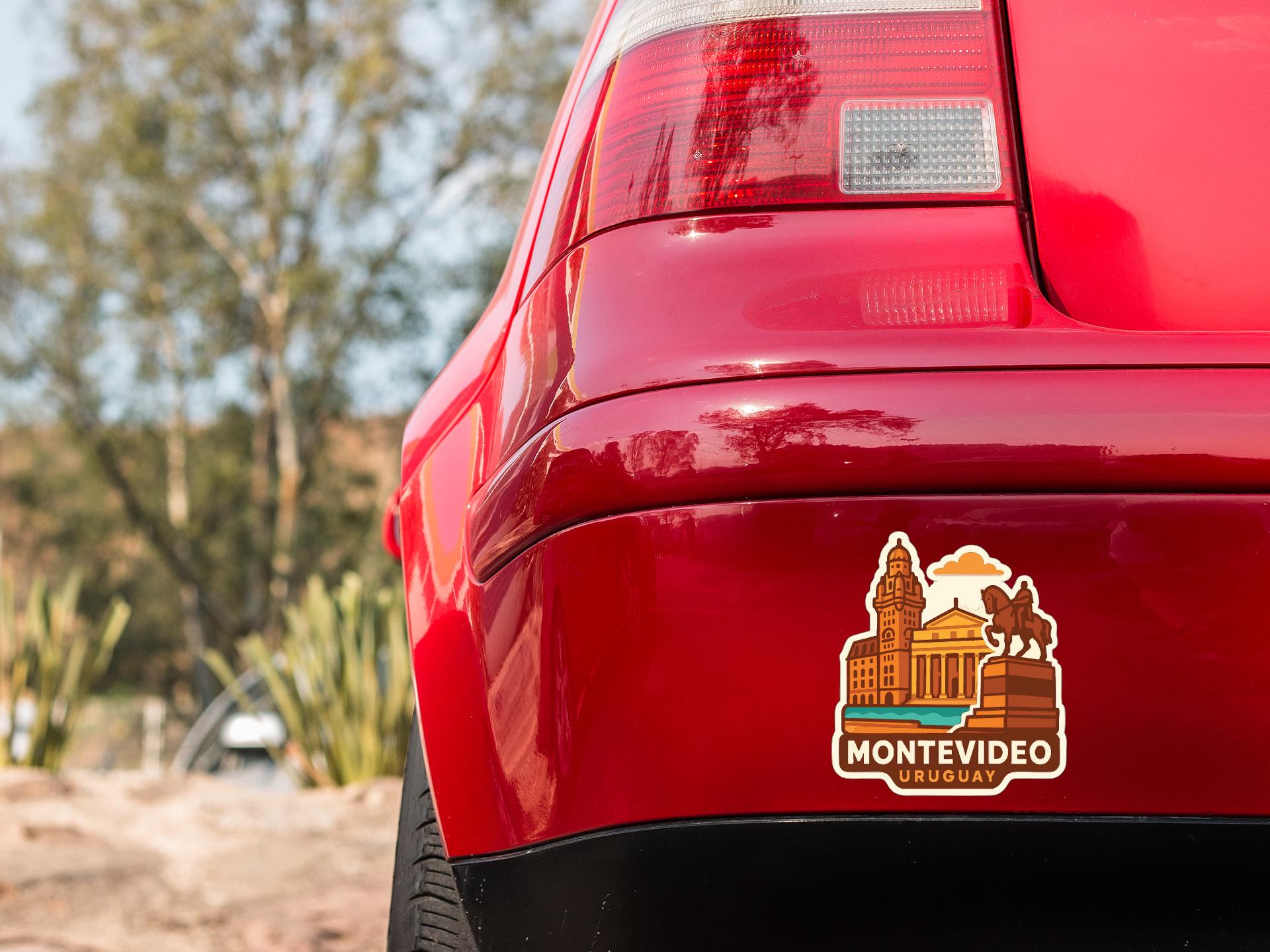 the rear end of a red car with a sticker on the trunk that features a cityscape and the text "MONTIVEDO URUGUAY".