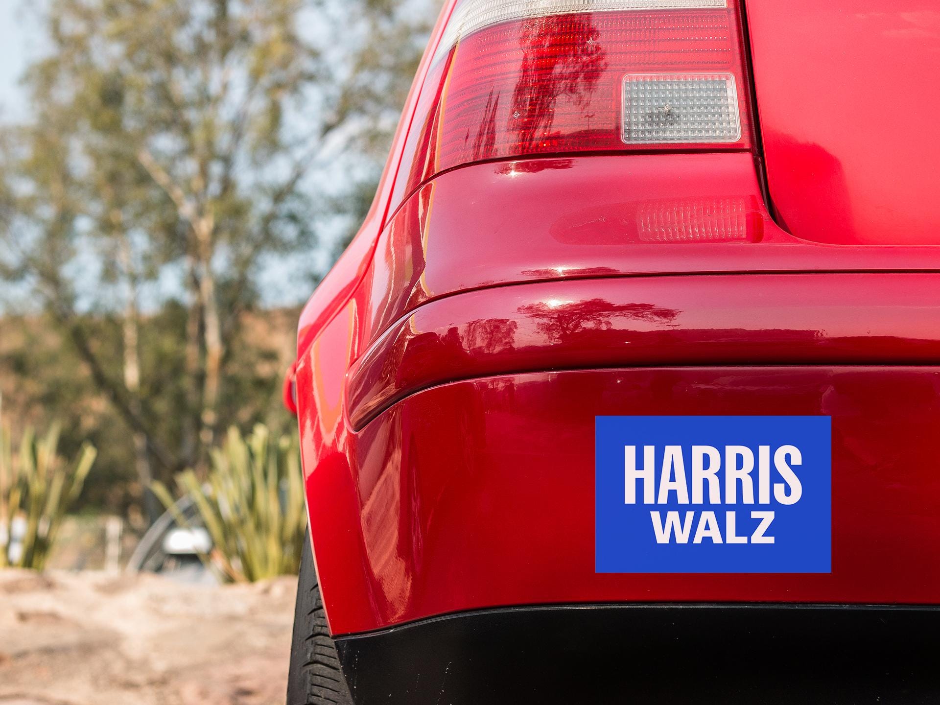 a close up of a red car with a sticker on it