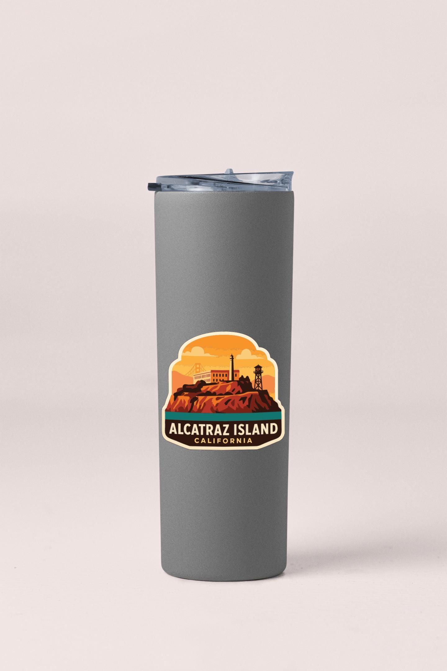A gray insulated tumbler with a label that says "ALCATRZ ISLAND CALIFORNIA" printed on it.