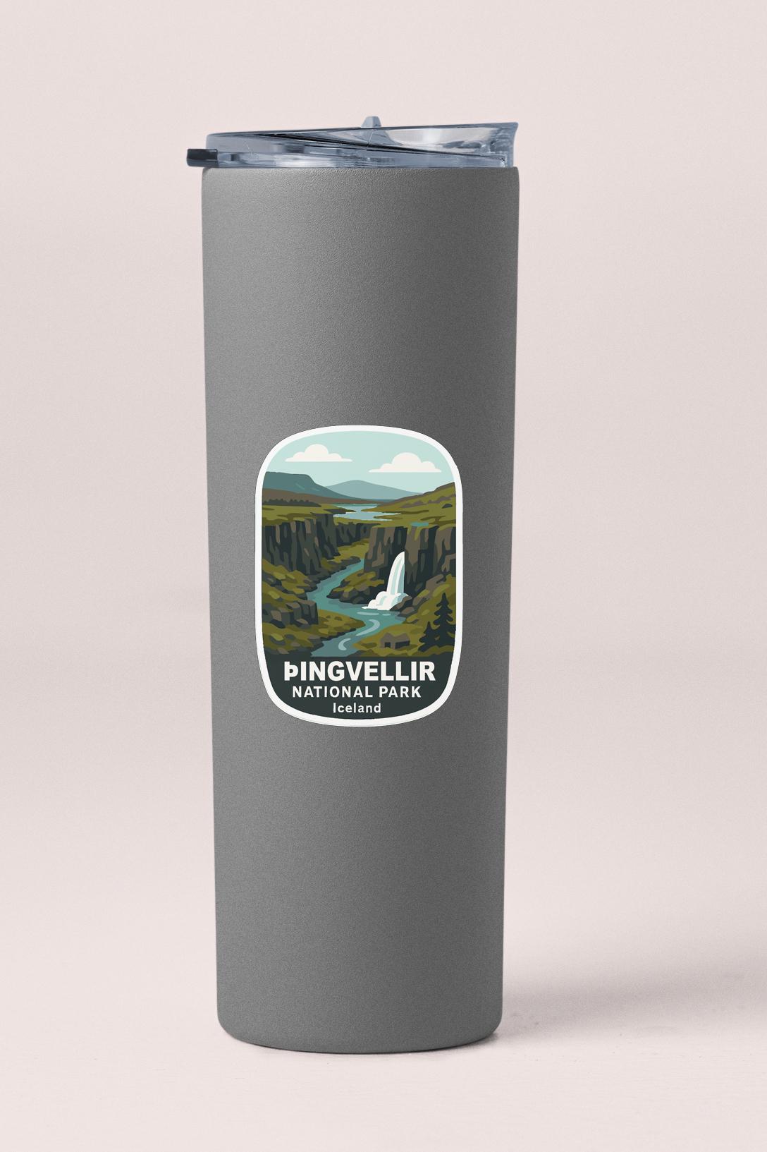 A gray insulated tumbler with a sticker depicting the scenic landscape of Pingvellir National Park in Iceland.