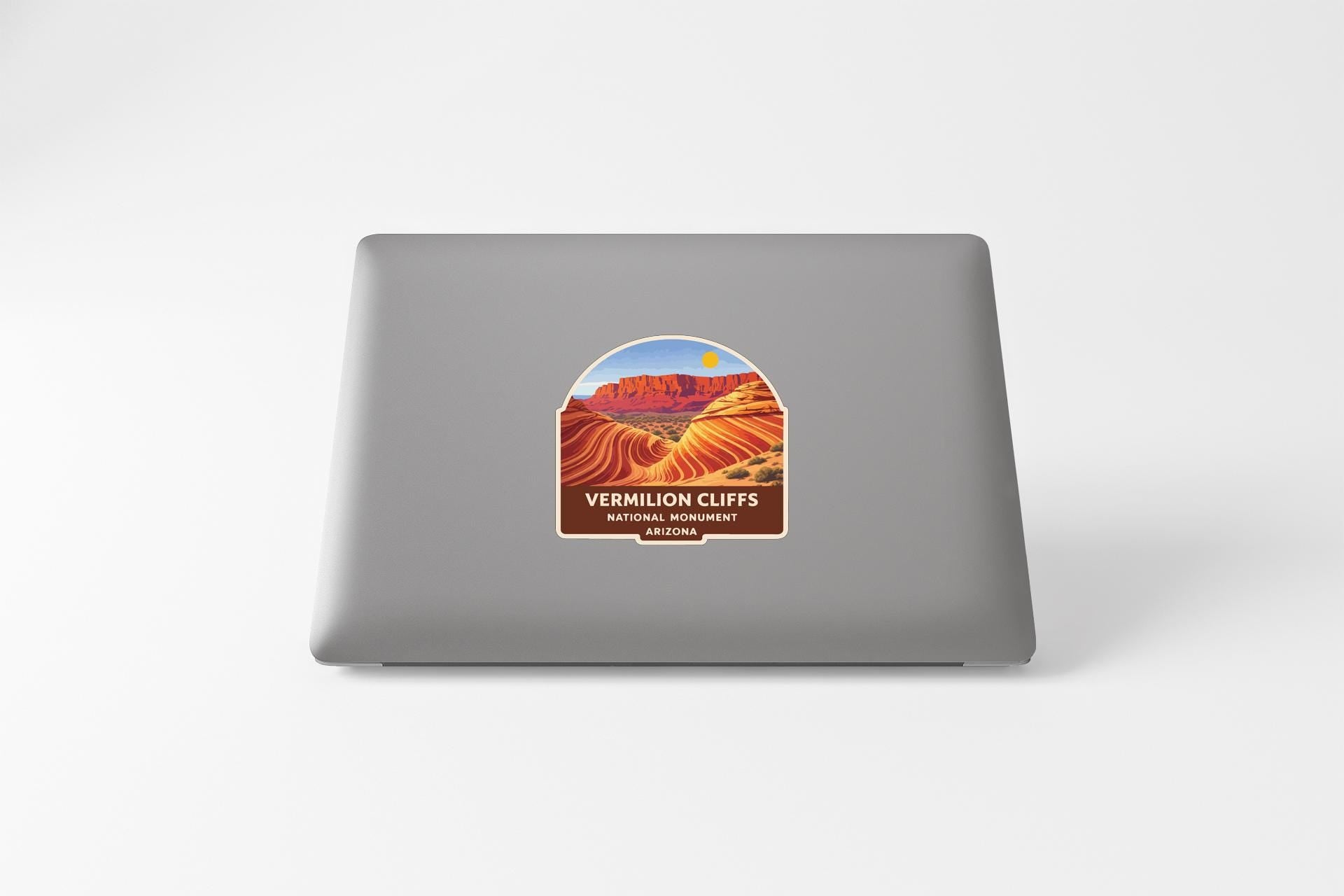 a sticker with a desert landscape and mountains on the back of a laptop computer.