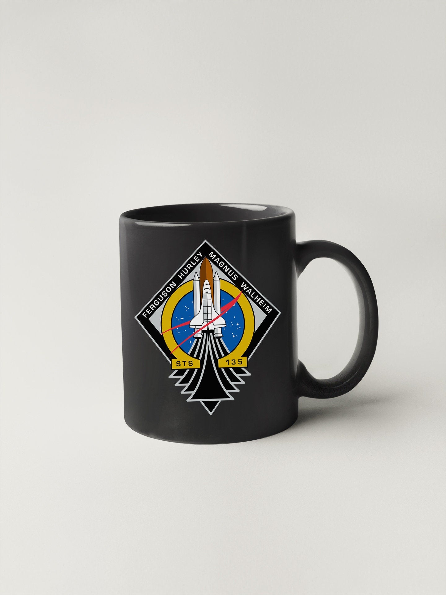 a black coffee mug with a space shuttle on it