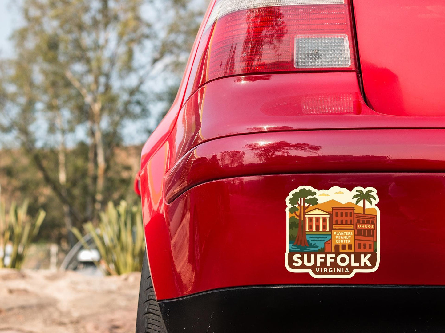 the rear end of a red car with a sticker on the back window that says "SUFFOLK VIRGINIA".