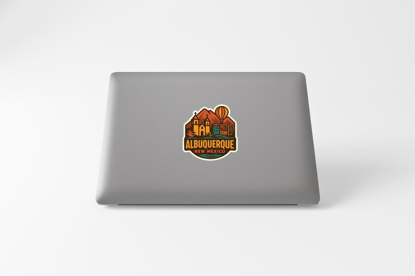 a sticker on the back of a laptop that says "ALBUQUERQUE" and "TENACIÓN".