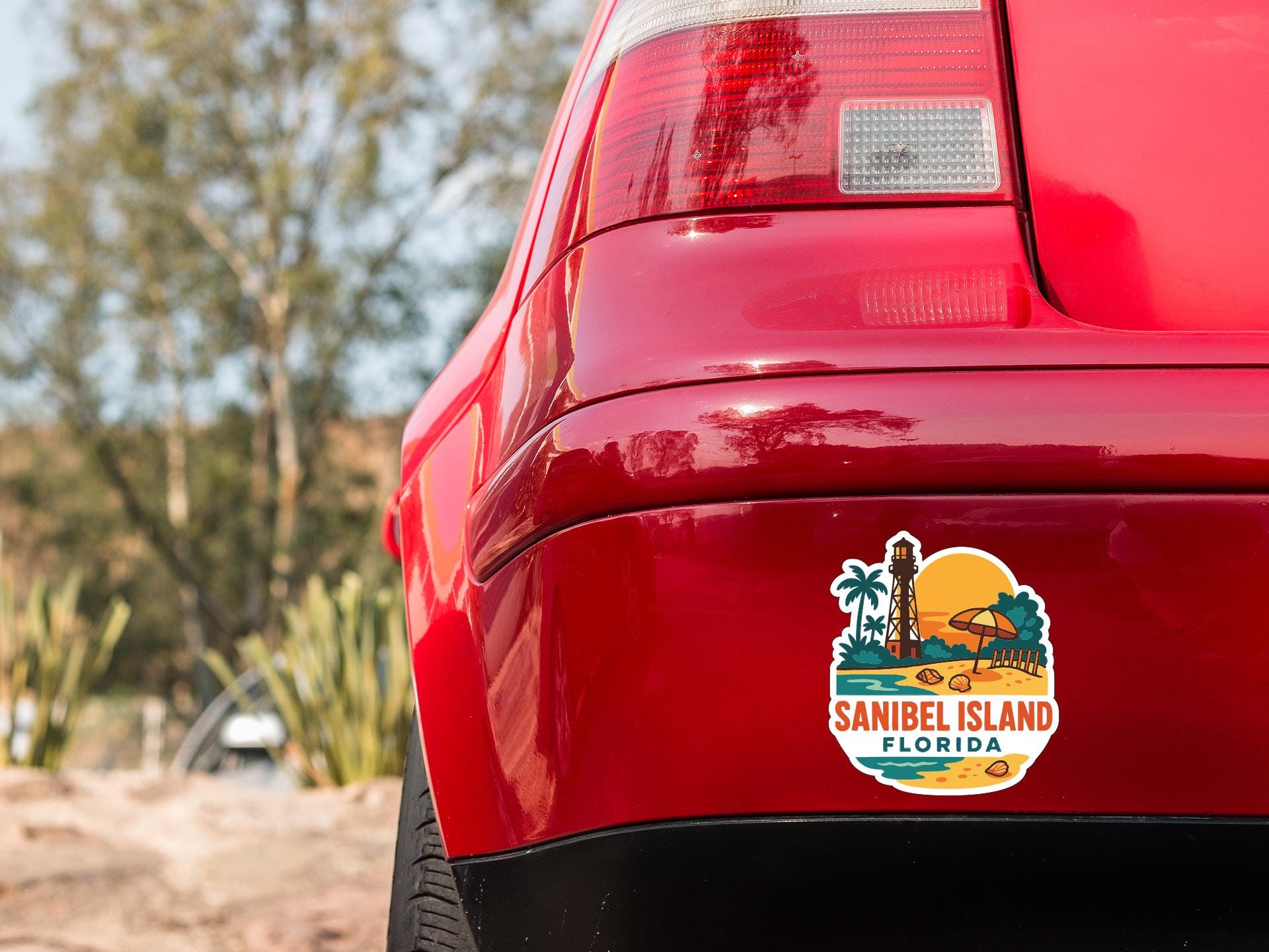 the rear end of a red car with a sticker on it, featuring a tropical island landscape.