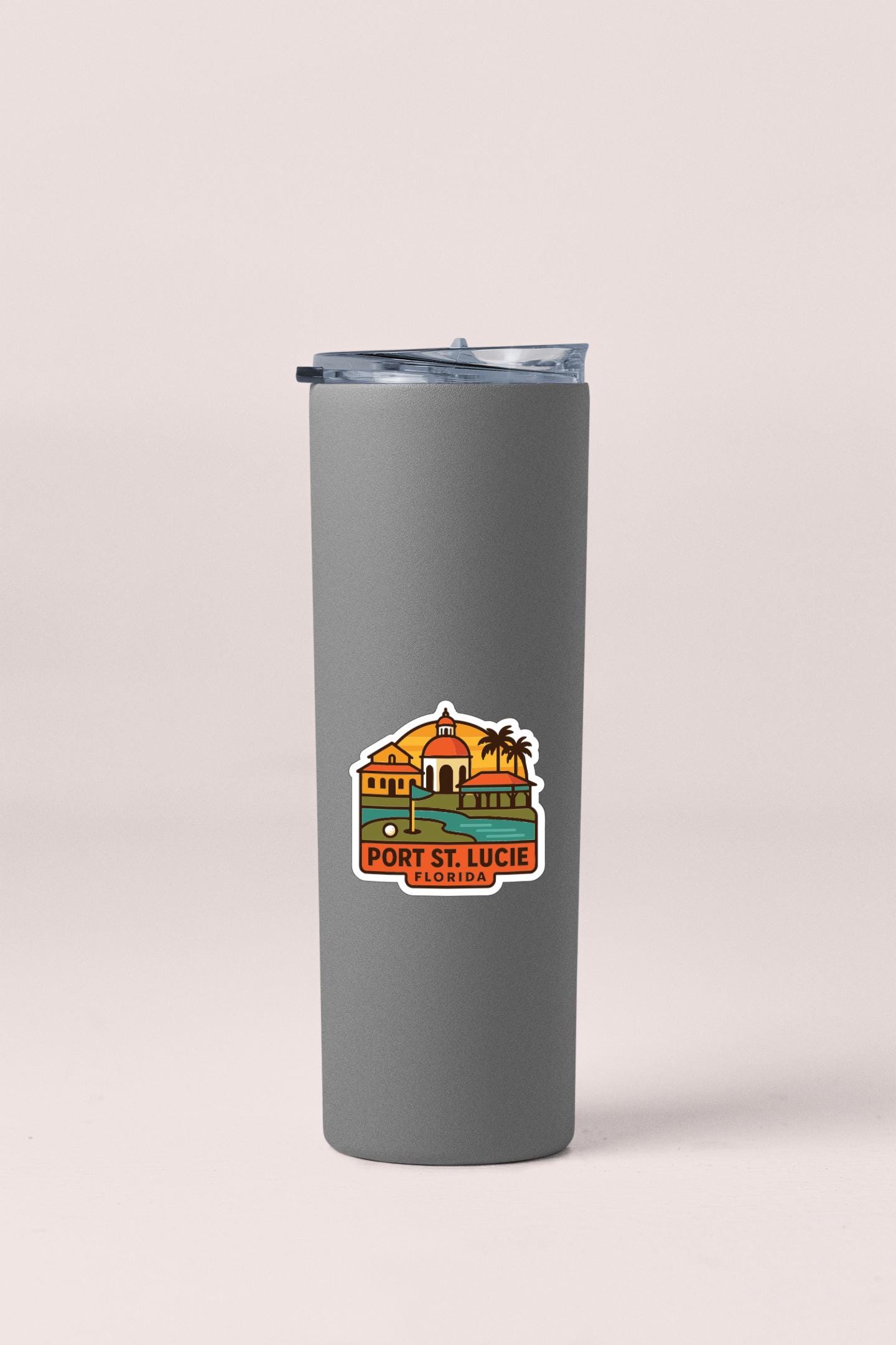 A gray insulated tumbler with a sticker depicting a tropical island and the text "PORT ST. LUCIE FLORIDA".