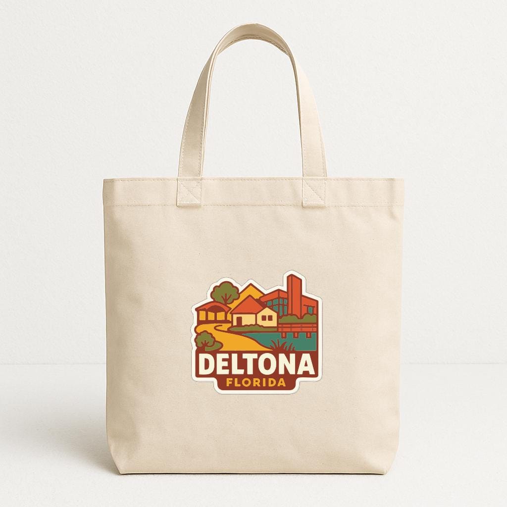 A beige tote bag with a printed design depicting a cityscape and the text "DELTONA FLORIDA" printed on it.