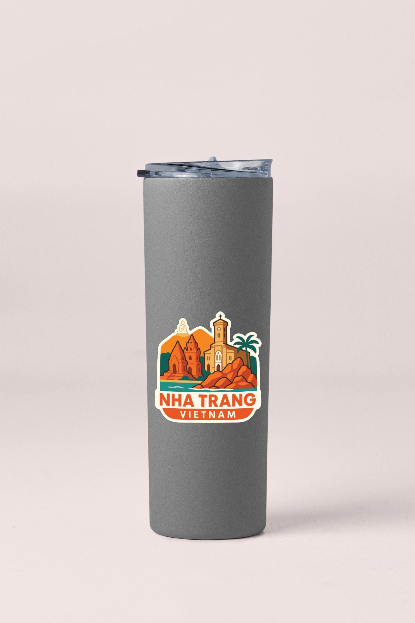 A gray insulated tumbler with a sticker depicting a cityscape and the text "NHA TRANG VIETNAM" printed on it.