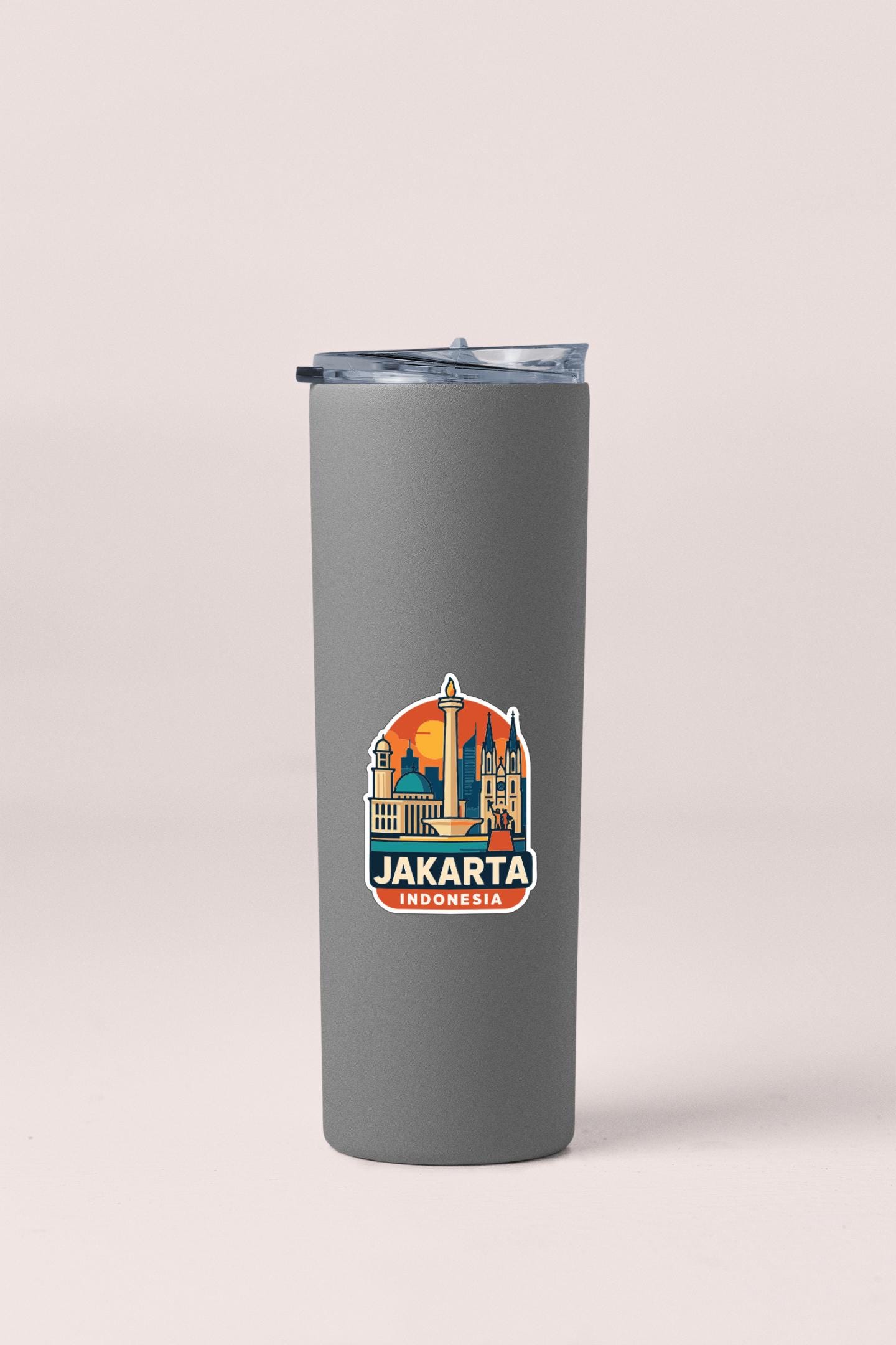 A gray insulated tumbler with a sticker depicting the skyline of Jakarta, Indonesia.